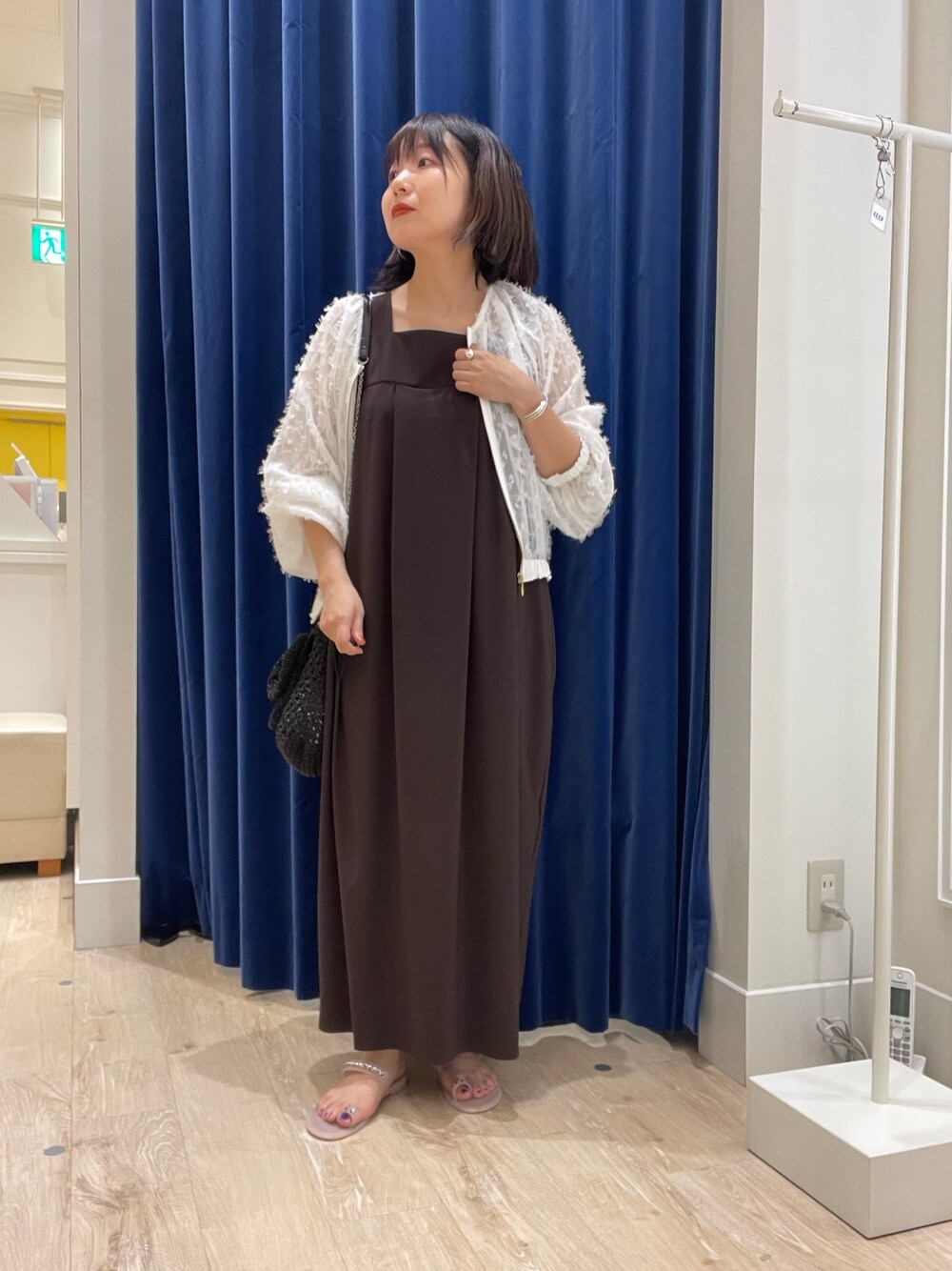 ブラウン系のワンピース、ホワイト系のブルゾンを着用したレディースの夏コーディネートの1枚目の写真