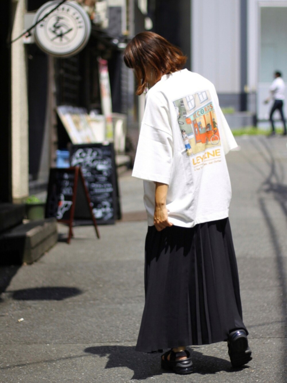 ブラック系のサンダル、ブラック系のスカート、ホワイト系のTシャツ/カットソーを着用したレディースの夏コーディネートの1枚目の写真