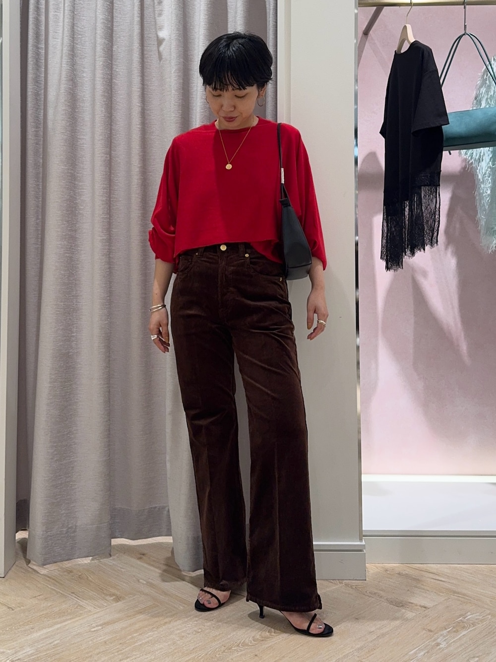 レッド系のニット/セーター、ブラウン系のその他パンツ、ブラック系のショルダーバッグを着用したレディースの夏コーディネートの1枚目の写真
