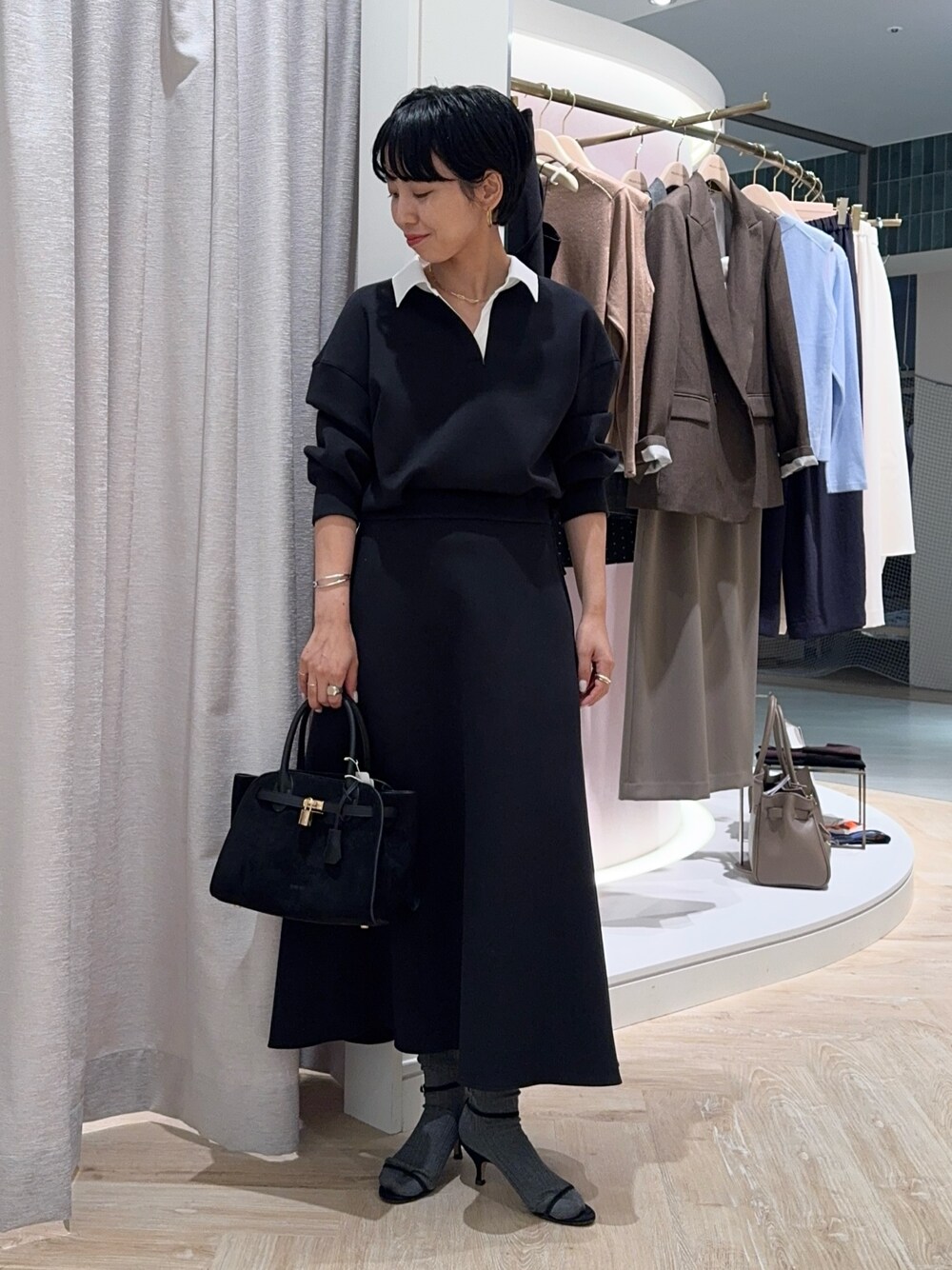 ブラック系のTシャツ/カットソー、ブラック系のトートバッグ、ブラック系のスカートを着用したレディースの秋コーディネートの1枚目の写真