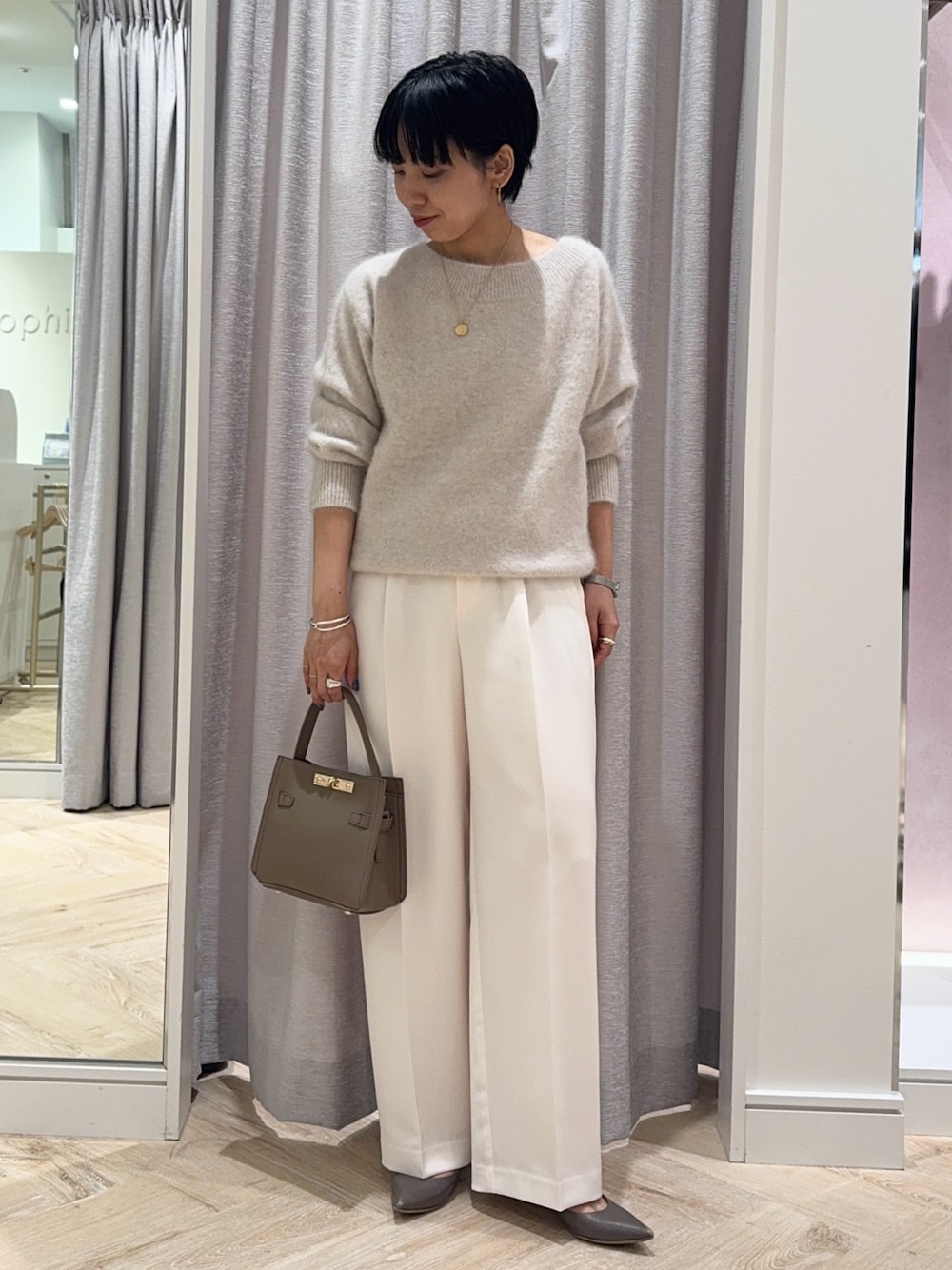 ベージュ系のニット/セーター、ベージュ系のショルダーバッグ、ホワイト系のその他パンツを着用したレディースの秋コーディネートの1枚目の写真