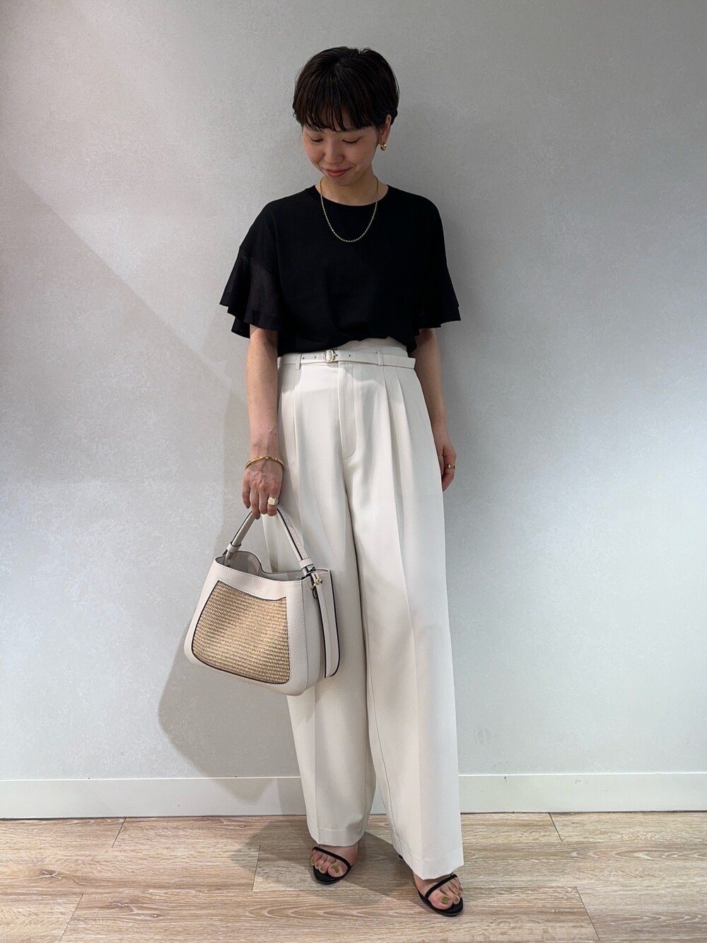 ブラック系のニット/セーター、ホワイト系のその他パンツ、ベージュ系のバックパック/リュックを着用したレディースの夏コーディネートの1枚目の写真