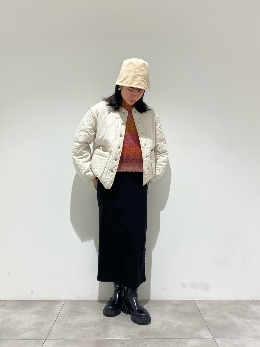 ホワイト系のダウンジャケット/コート、ピンク系のニット/セーター、ブラック系のスカートを着用したレディースの冬コーディネートの1枚目の写真