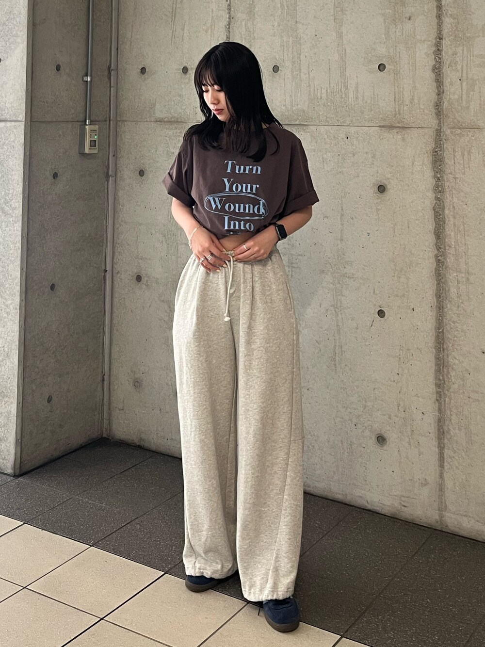 ブラウン系のTシャツ/カットソー、グレー系のスウェットパンツを着用したレディースの春コーディネートの1枚目の写真