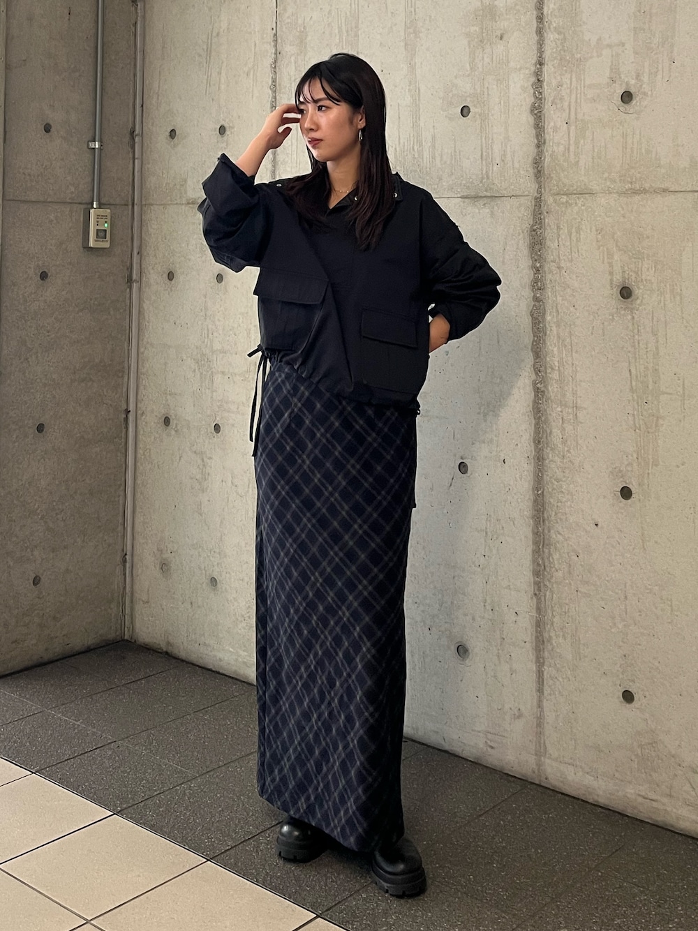 ブラック系のパーカー、ブルー系のスカートを着用したレディースの秋コーディネートの1枚目の写真