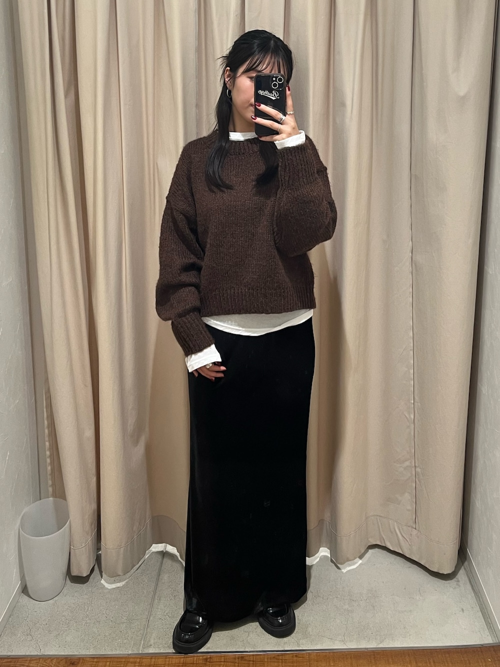 ブラウン系のニット/セーター、ブラック系のスカートを着用したレディースの秋コーディネートの1枚目の写真