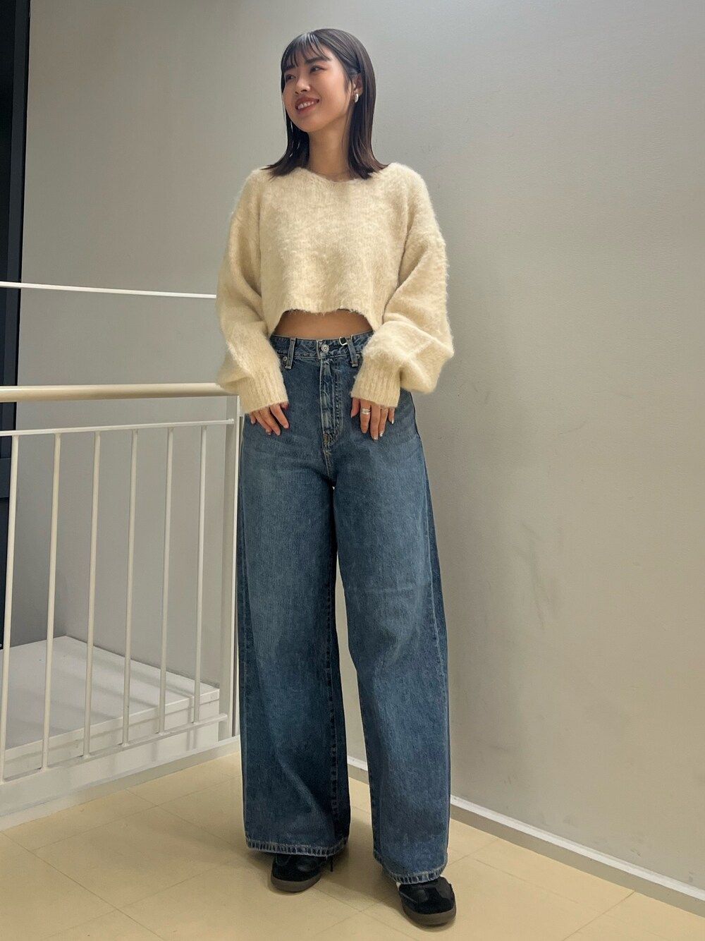 ホワイト系のニット/セーター、ブルー系のデニムパンツを着用したレディースの秋コーディネートの1枚目の写真