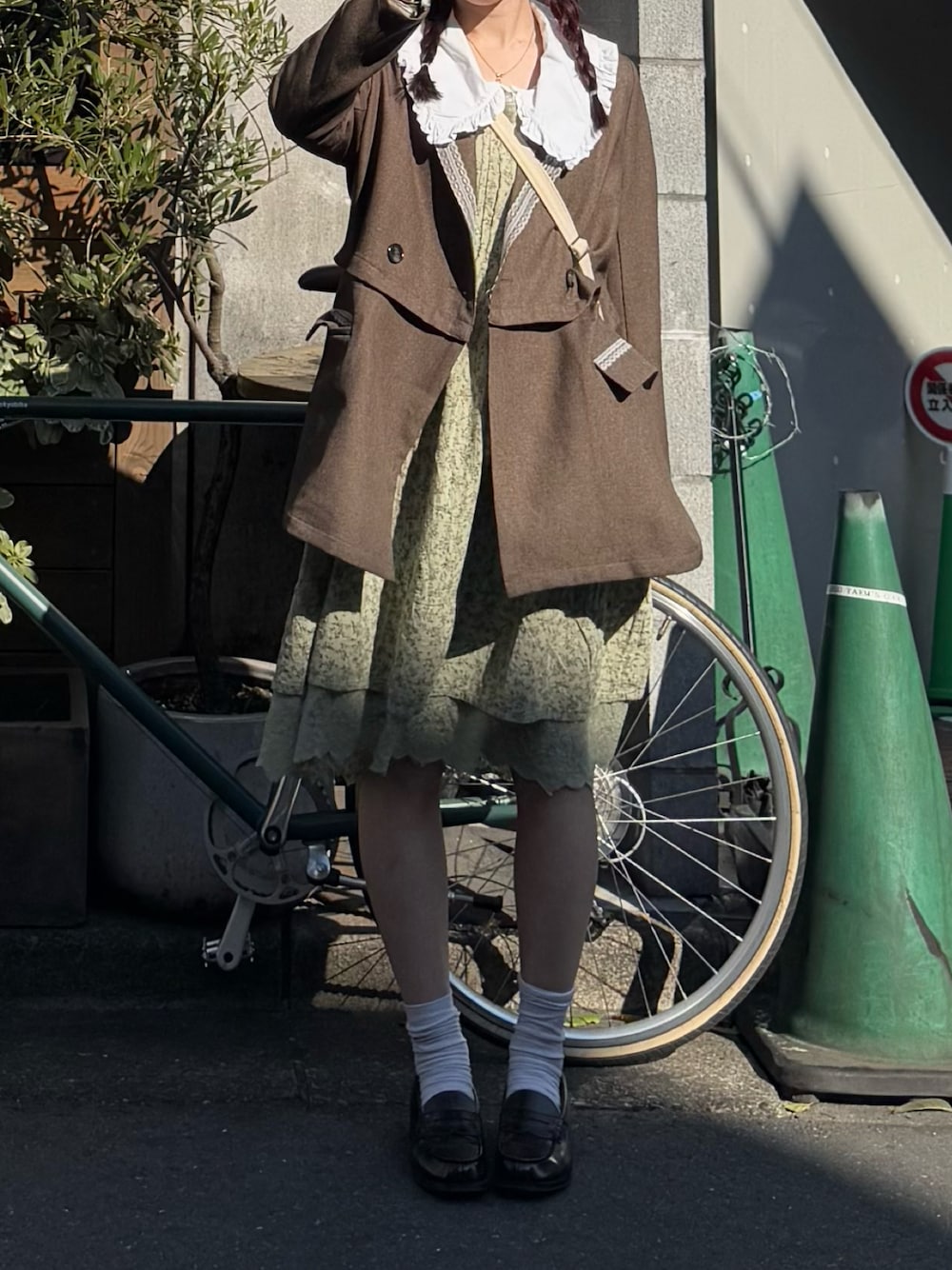 ブラウン系のローファー、ブラウン系のテーラードジャケット、グリーン系のワンピースを着用したレディースの秋コーディネートの1枚目の写真