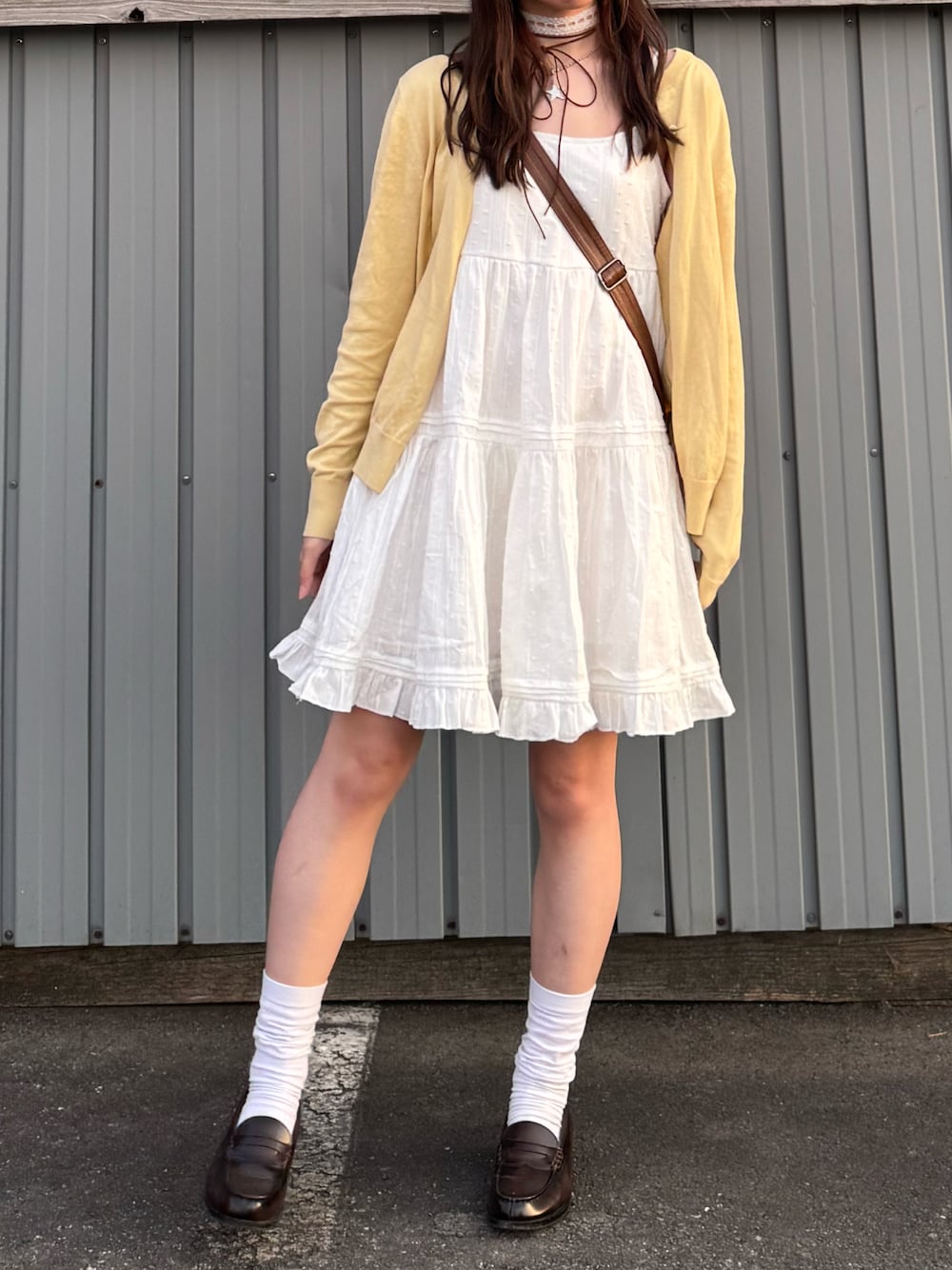 ホワイト系のワンピース、ブラウン系のローファー、イエロー系のカーディガン/ボレロを着用したレディースの秋コーディネートの1枚目の写真