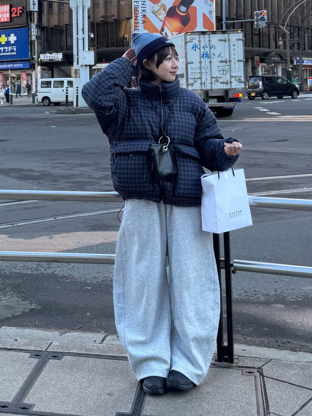 ブルー系のブルゾン、グレー系のスウェットパンツ、ブラック系のショルダーバッグを着用したレディースの冬コーディネートの1枚目の写真