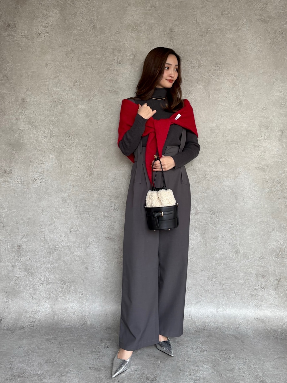 ブラック系のショルダーバッグ、ゴールド系のチョーカーを着用したレディースの冬コーディネートの1枚目の写真