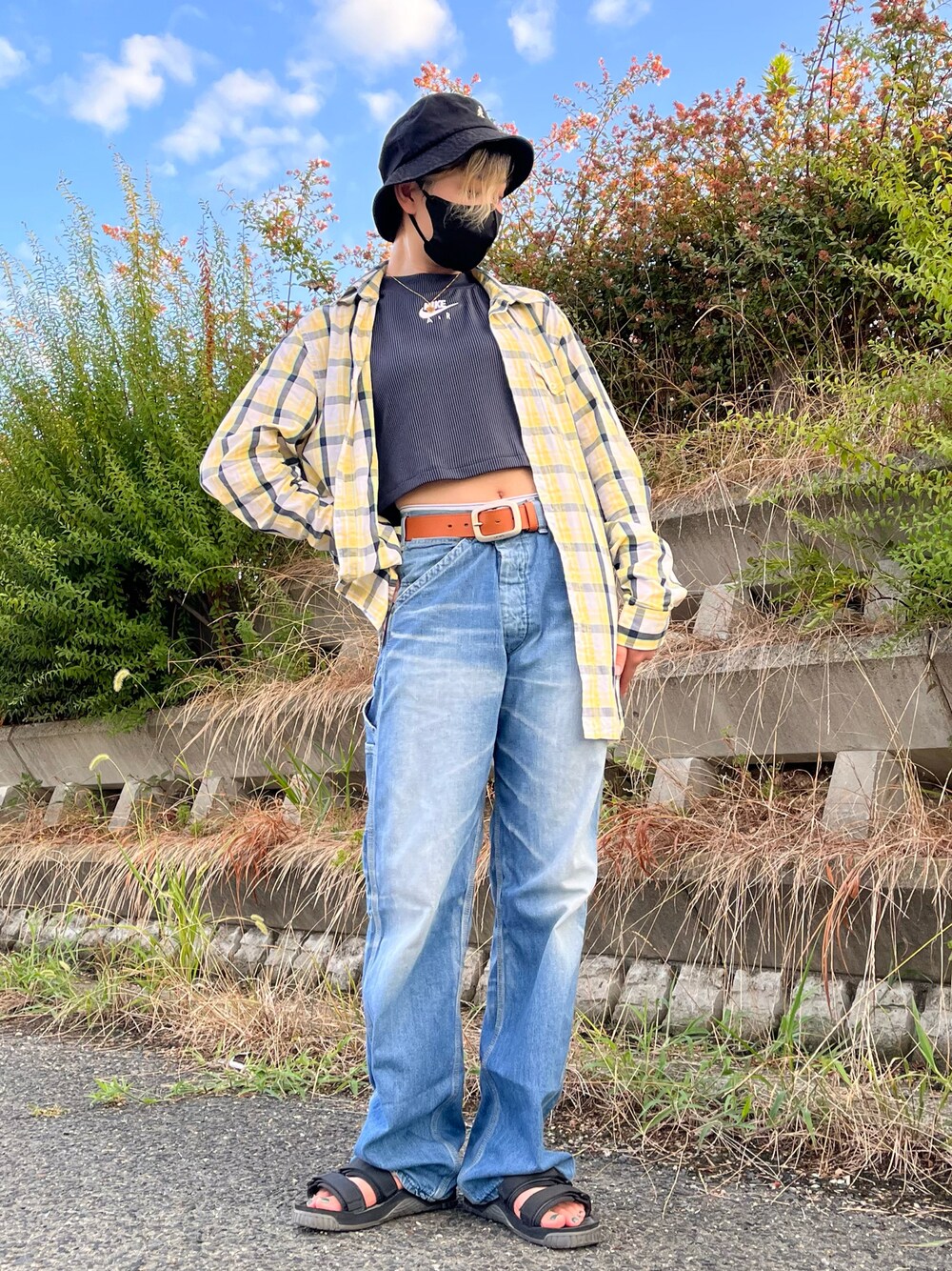 イエロー系のシャツ/ブラウス、ブラック系のタンクトップ、ブルー系のデニムパンツを着用したレディースの夏コーディネートの1枚目の写真