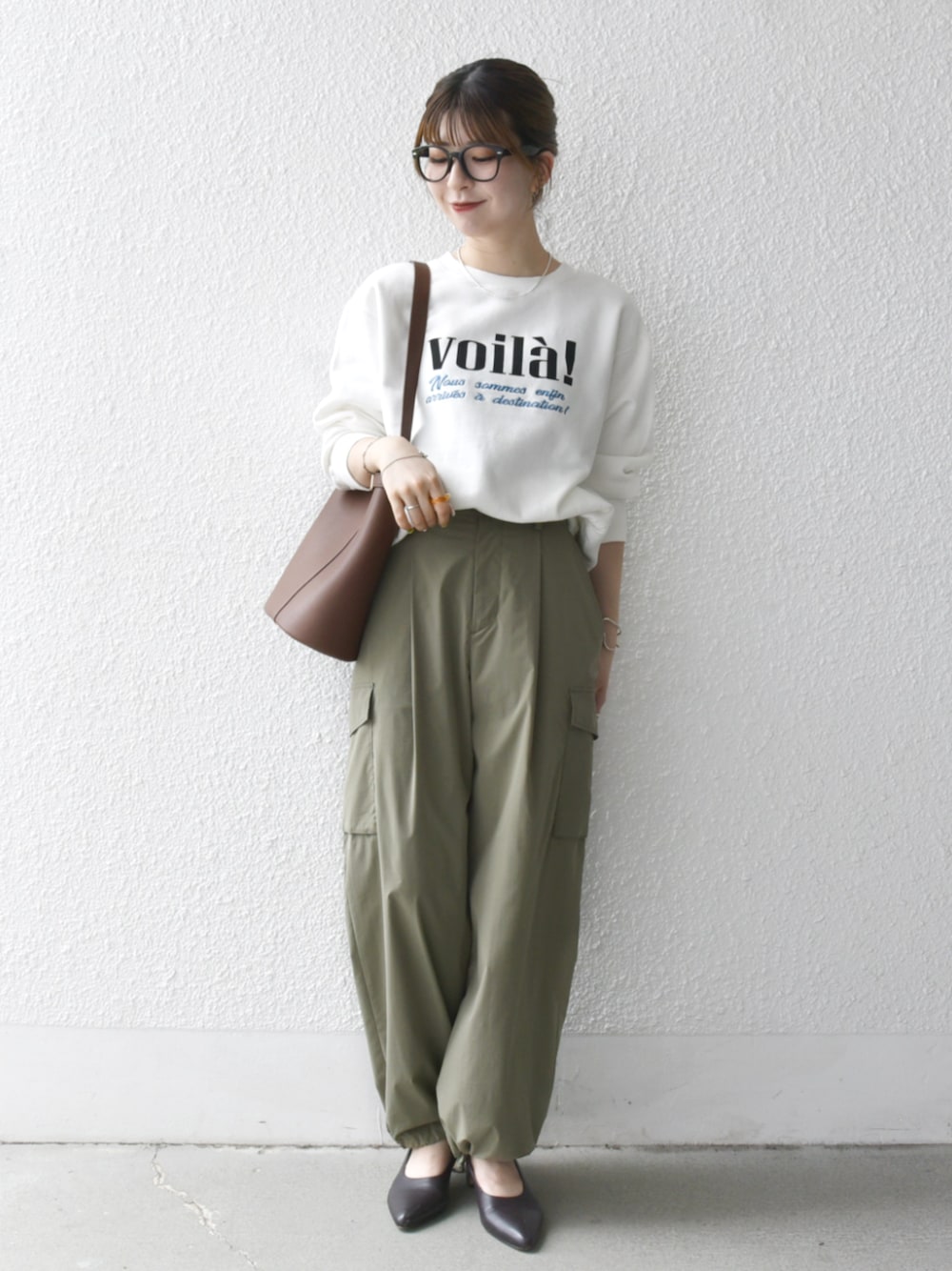 グリーン系のカーゴパンツ、ブラウン系のショルダーバッグ、ホワイト系のスウェットを着用したレディースの秋コーディネートの1枚目の写真