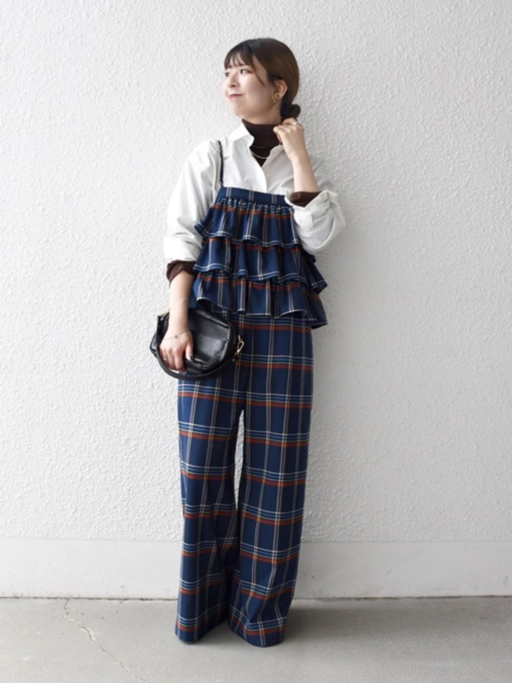 ホワイト系のシャツ/ブラウス、ブラウン系のニット/セーター、ブルー系のサロペット/オーバーオールを着用したレディースの冬コーディネートの1枚目の写真