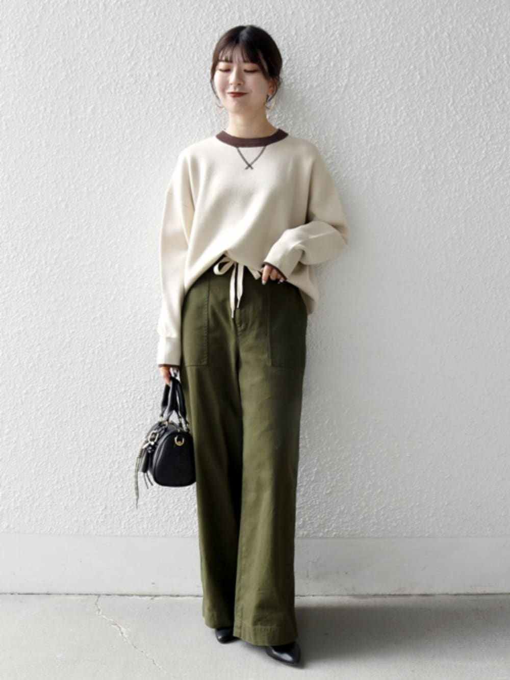 ベージュ系のニット/セーター、グリーン系のその他パンツ、グレー系のキーケース/キーアクセサリーを着用したレディースの冬コーディネートの1枚目の写真