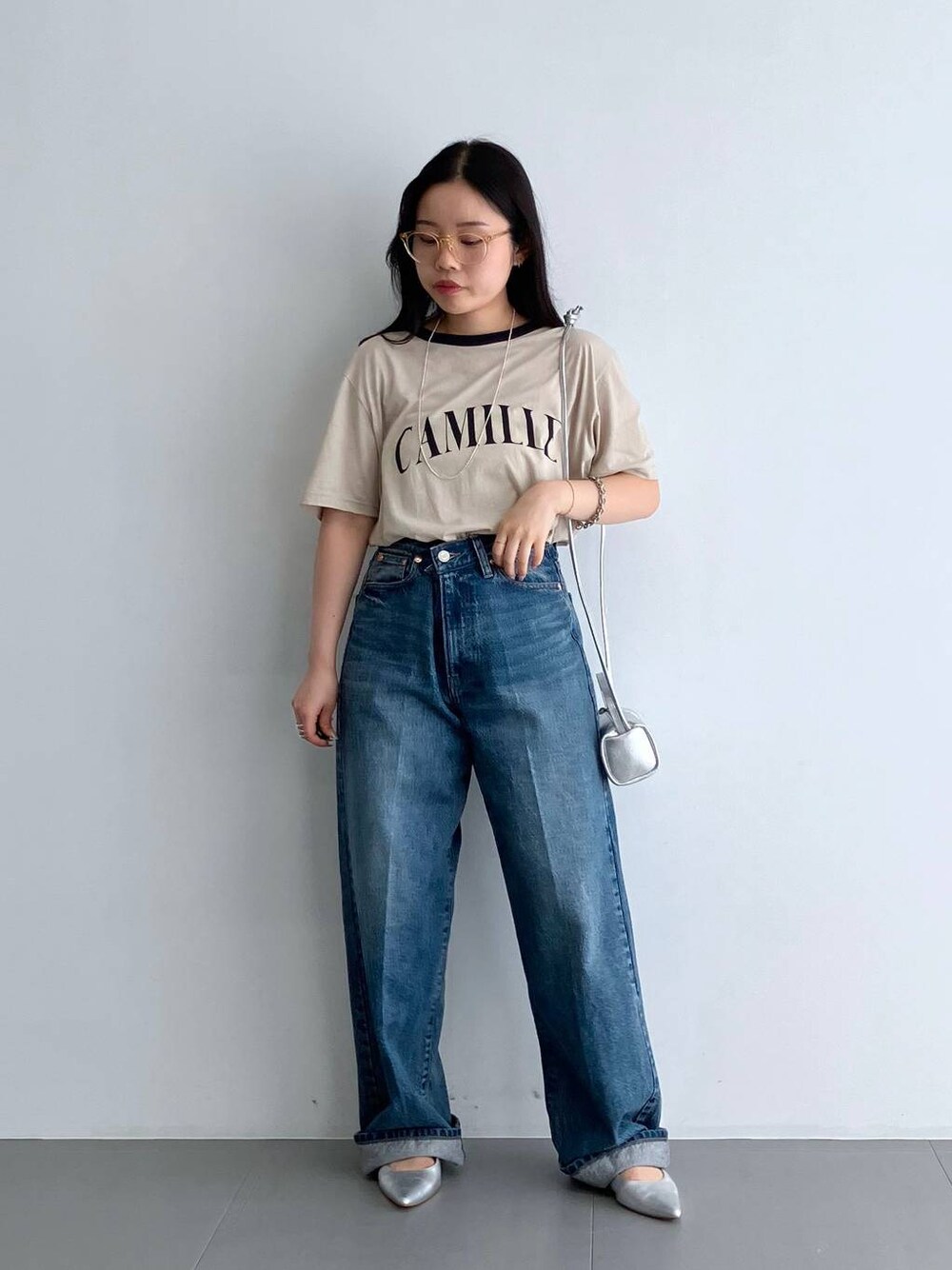 ブルー系のデニムパンツ、シルバー系のパンプス、ベージュ系のTシャツ/カットソーを着用したレディースの夏コーディネートの1枚目の写真