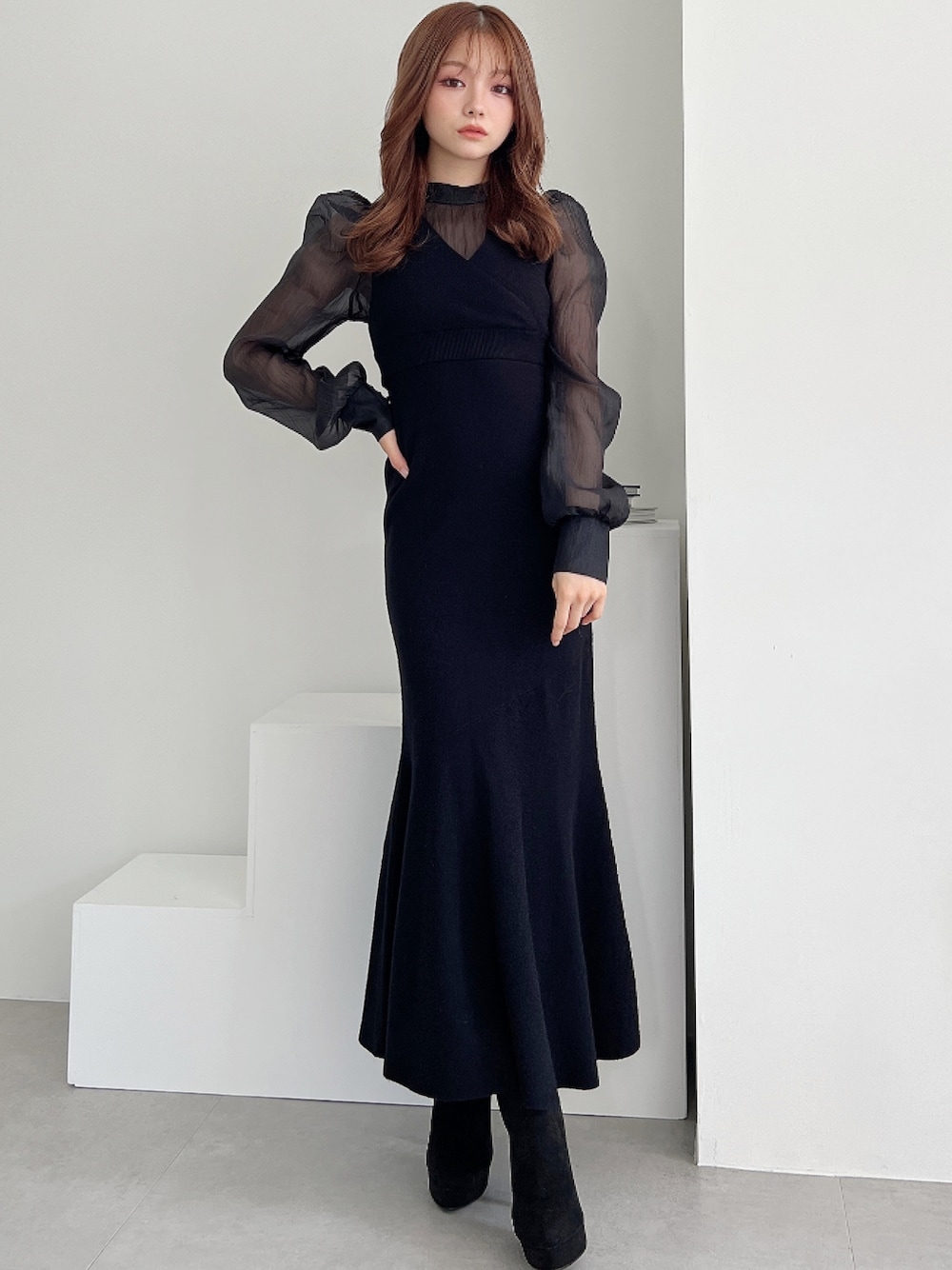 ブラック系のワンピース、ブラック系のブーツを着用したレディースの秋コーディネートの1枚目の写真