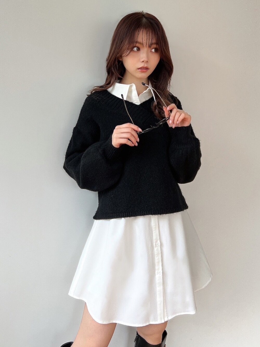 ブラック系のニット/セーター、ホワイト系のワンピース、ブラック系のブーツを着用したレディースの冬コーディネートの1枚目の写真