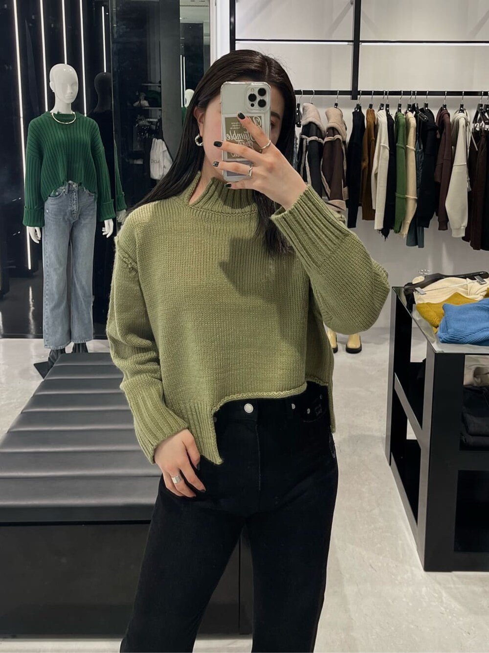 ブラック系のブーツ、ブラック系のデニムパンツ、ベージュ系のニット/セーターを着用したレディースの秋コーディネートの1枚目の写真