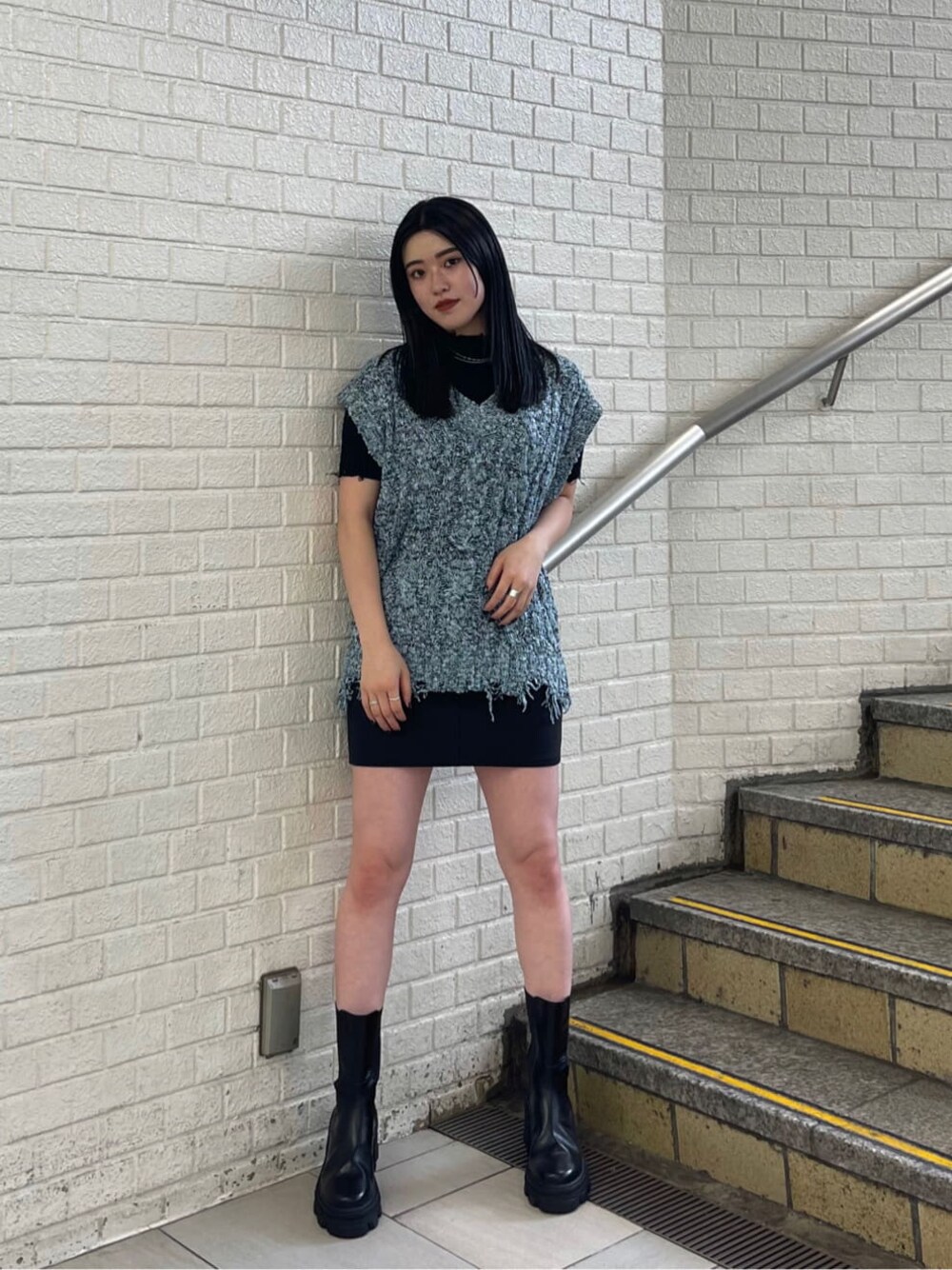 ブラック系のスカート、ブラック系のブーツ、ブラック系のニット/セーターを着用したレディースの夏コーディネートの1枚目の写真