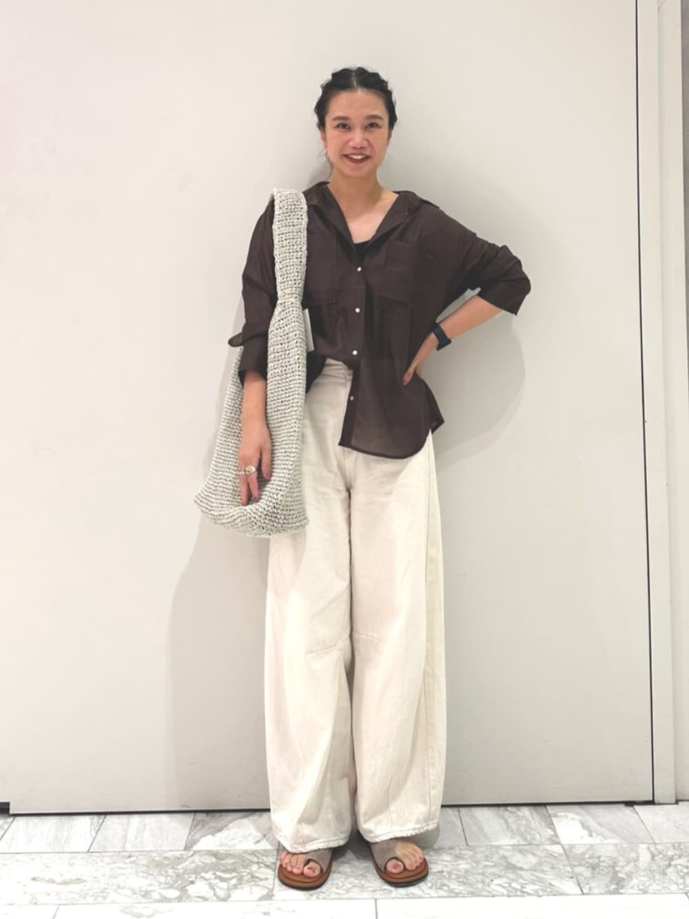 ブラウン系のシャツ/ブラウス、ホワイト系のデニムパンツ、グレー系のショルダーバッグを着用したレディースの夏コーディネートの1枚目の写真