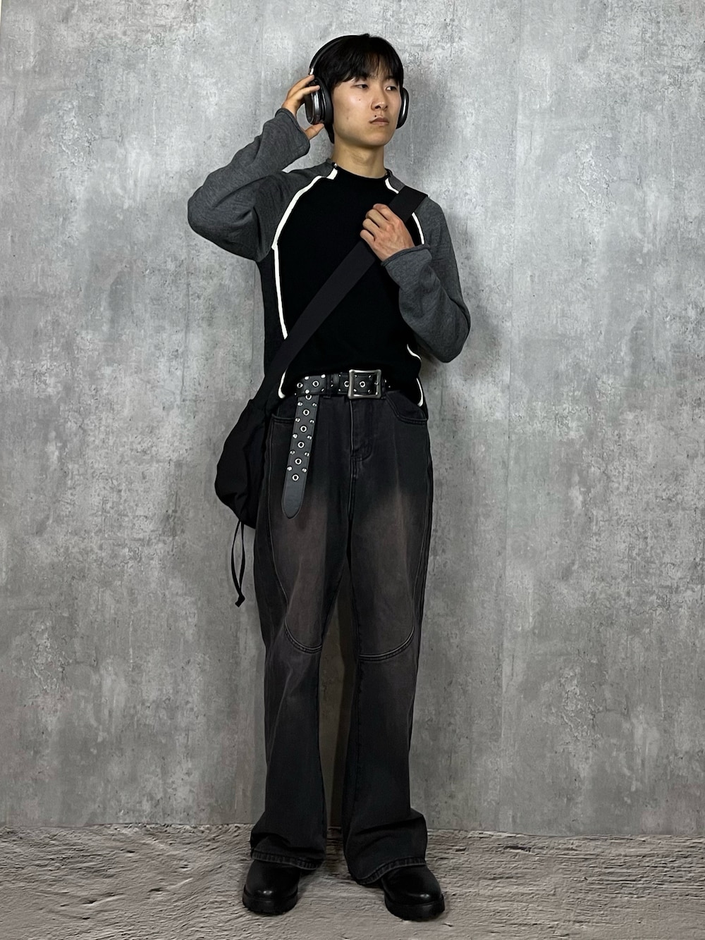 ブラック系のデニムパンツ、ブラック系のブーツ、ブラック系のショルダーバッグを着用したメンズの春コーディネートの1枚目の写真