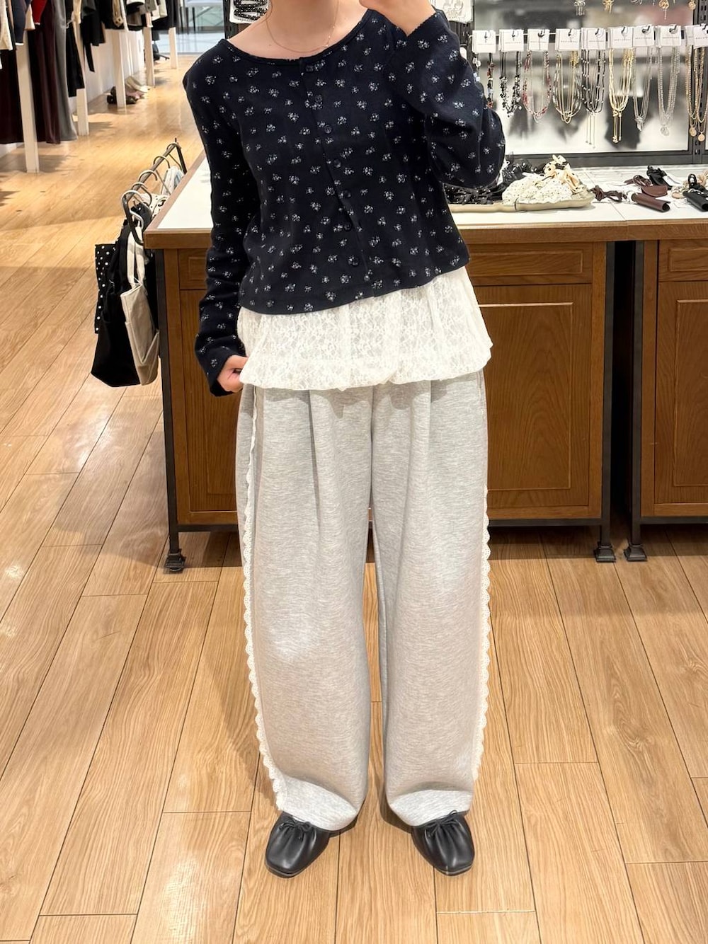 グレー系のスウェットパンツ、ホワイト系のキャミソールを着用したレディースの秋コーディネートの1枚目の写真