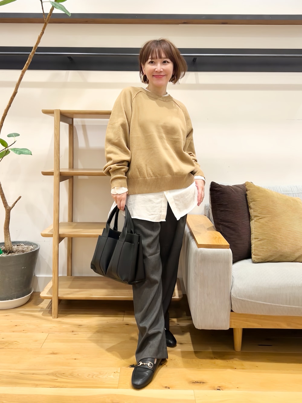 ベージュ系のニット/セーター、ホワイト系のシャツ/ブラウス、グレー系のその他パンツを着用したレディースの秋コーディネートの1枚目の写真