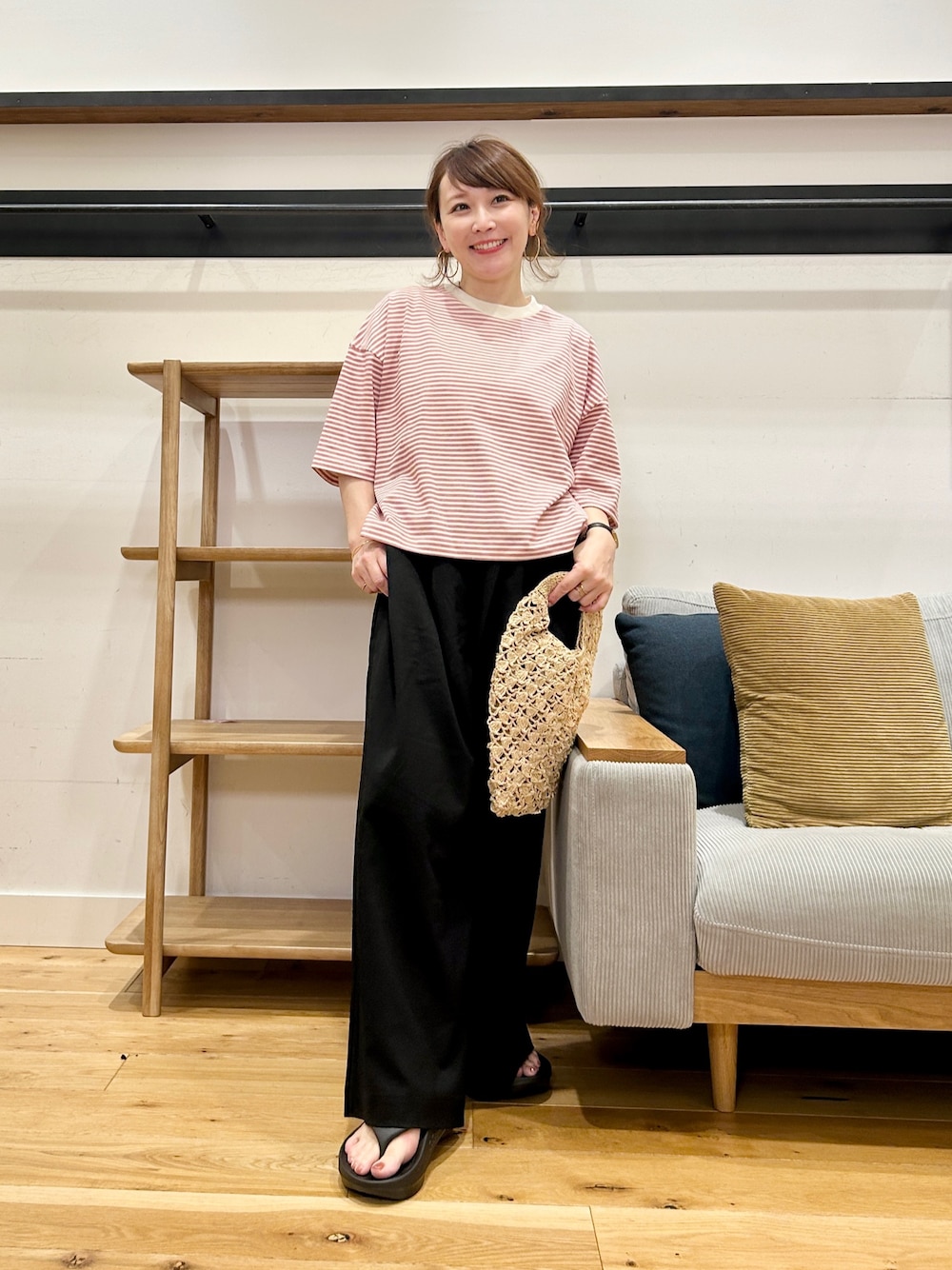 レッド系のTシャツ/カットソー、ブラック系のその他パンツ、ブラック系のサンダルを着用したレディースの春コーディネートの1枚目の写真