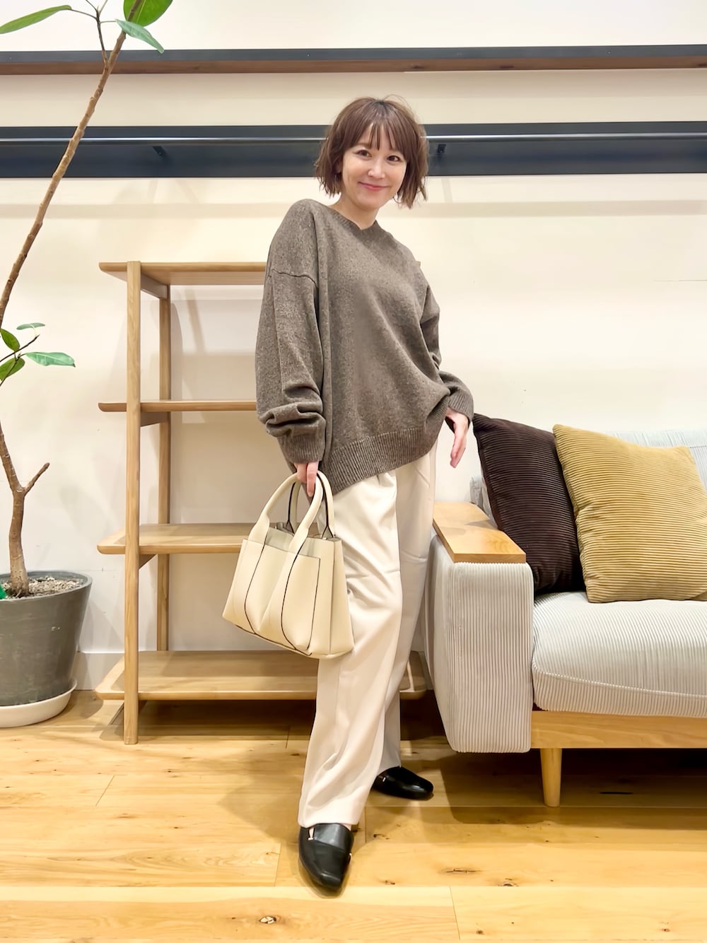 ブラウン系のニット/セーター、グレー系のその他パンツ、オレンジ系のトートバッグを着用したレディースの秋コーディネートの1枚目の写真