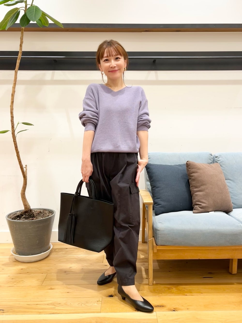 パープル系のニット/セーター、ブラック系のその他パンツ、ブラック系のトートバッグを着用したレディースの冬コーディネートの1枚目の写真