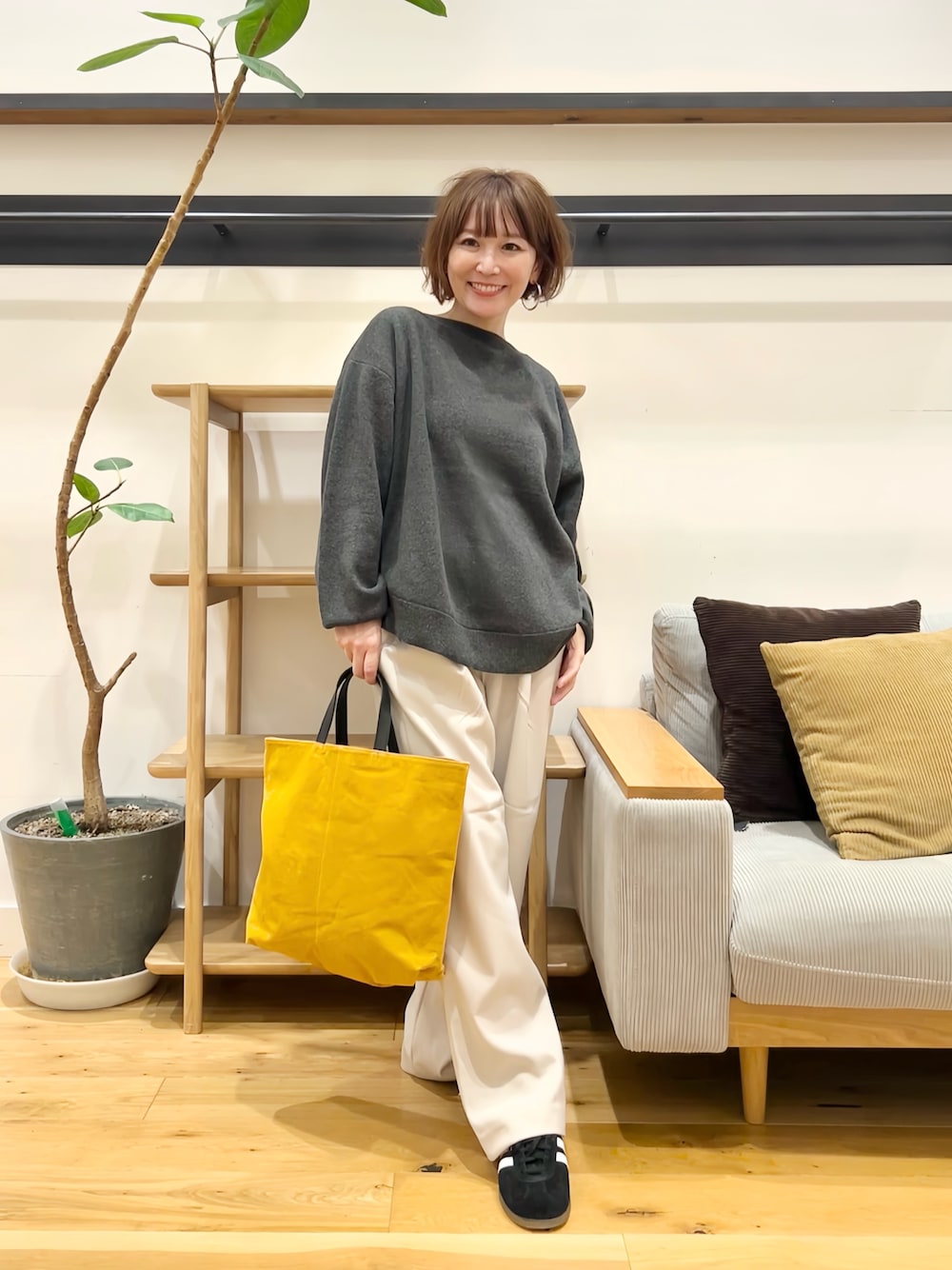 グレー系のニット/セーター、グレー系のその他パンツ、イエロー系のトートバッグを着用したレディースの秋コーディネートの1枚目の写真