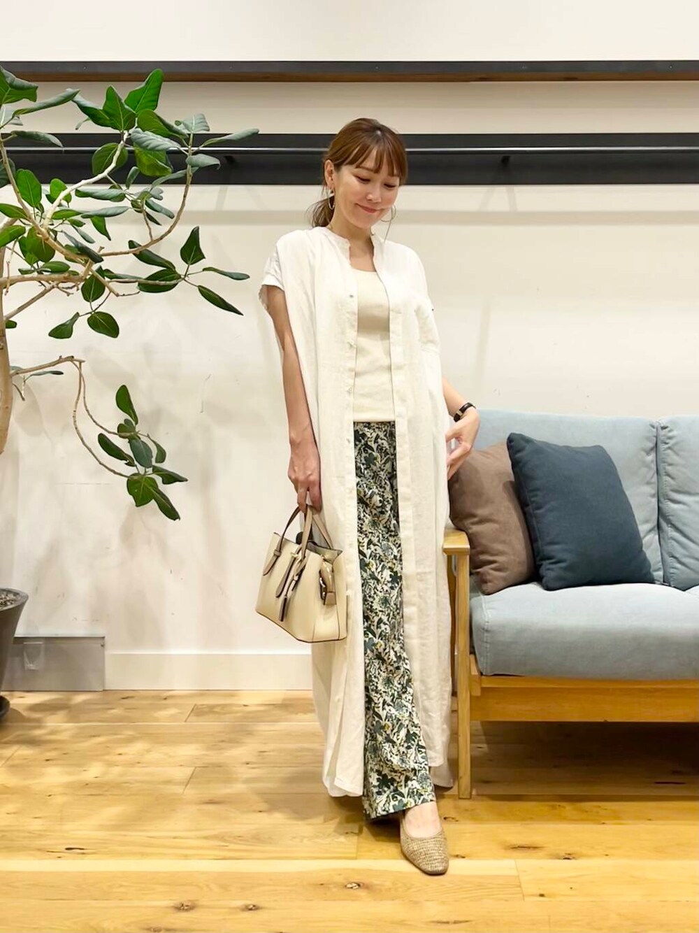 ホワイト系のハンドバッグ、ベージュ系のパンプス、ホワイト系のワンピースを着用したレディースの夏コーディネートの1枚目の写真