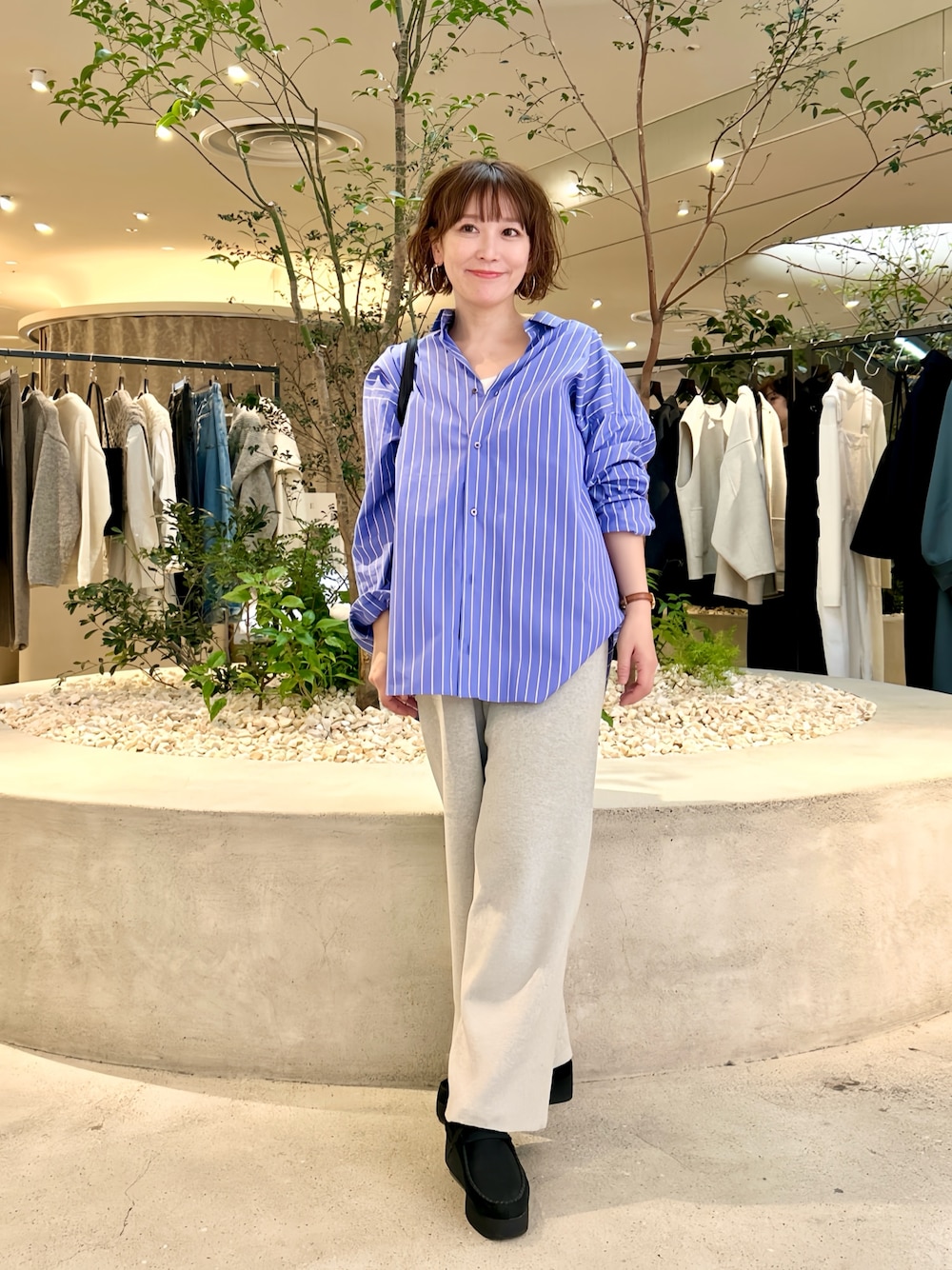 ブルー系のシャツ/ブラウス、ベージュ系のその他パンツ、ブラック系のトートバッグを着用したレディースの秋コーディネートの1枚目の写真
