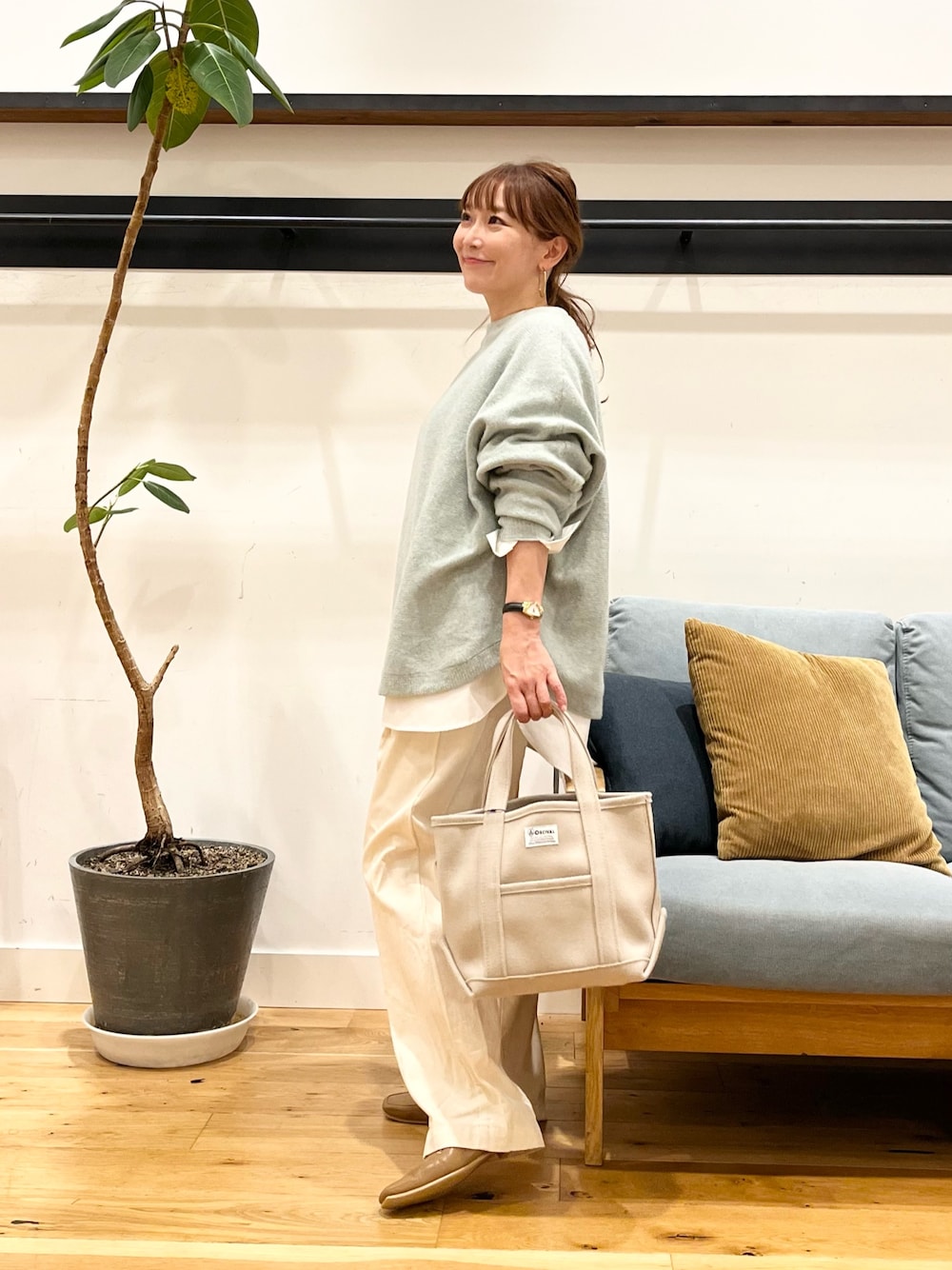 ピンク系のニット/セーター、ベージュ系のデニムパンツを着用したレディースの秋コーディネートの1枚目の写真