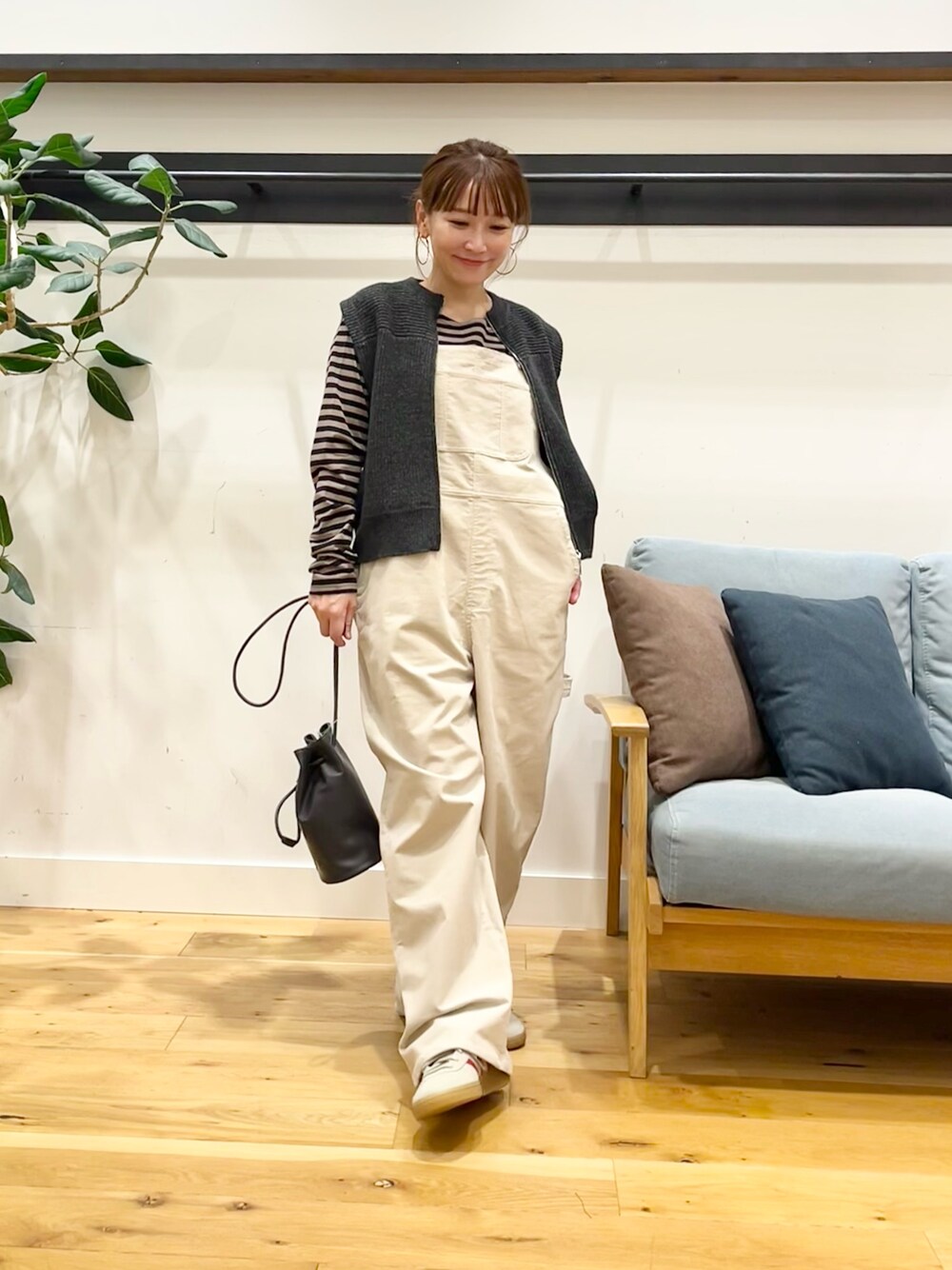 ホワイト系のサロペット/オーバーオール、グレー系のベスト、ベージュ系のTシャツ/カットソーを着用したレディースの秋コーディネートの1枚目の写真
