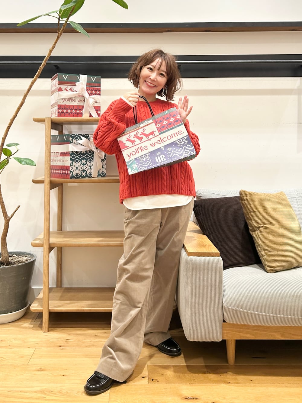 オレンジ系のニット/セーター、ホワイト系のTシャツ/カットソー、ベージュ系のその他パンツを着用したレディースの冬コーディネートの1枚目の写真