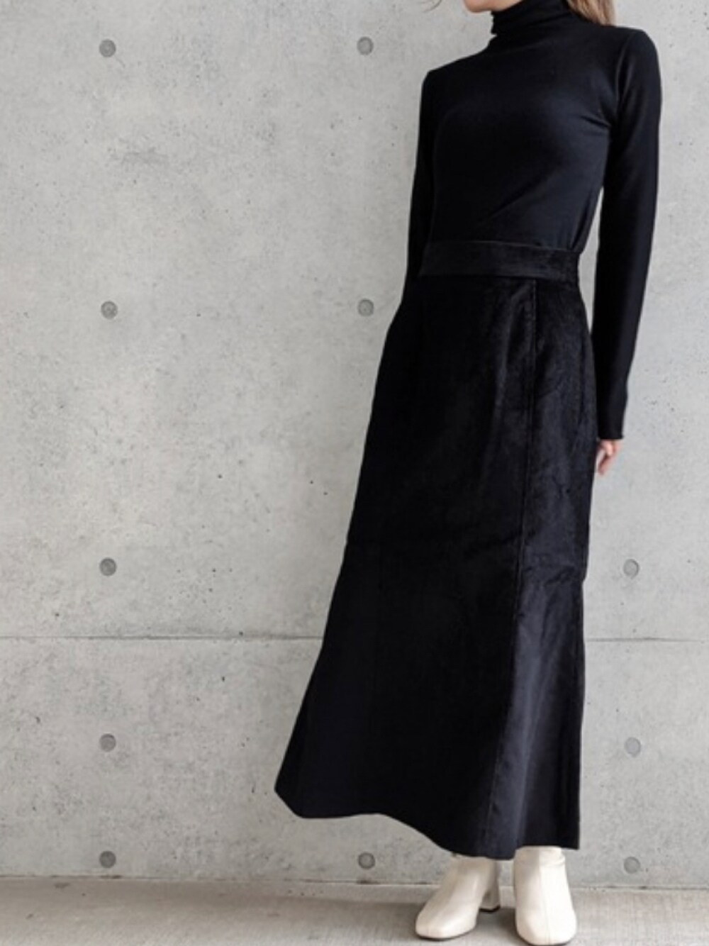 ブラック系のニット/セーター、ブラック系のスカートを着用したレディースの秋コーディネートの1枚目の写真