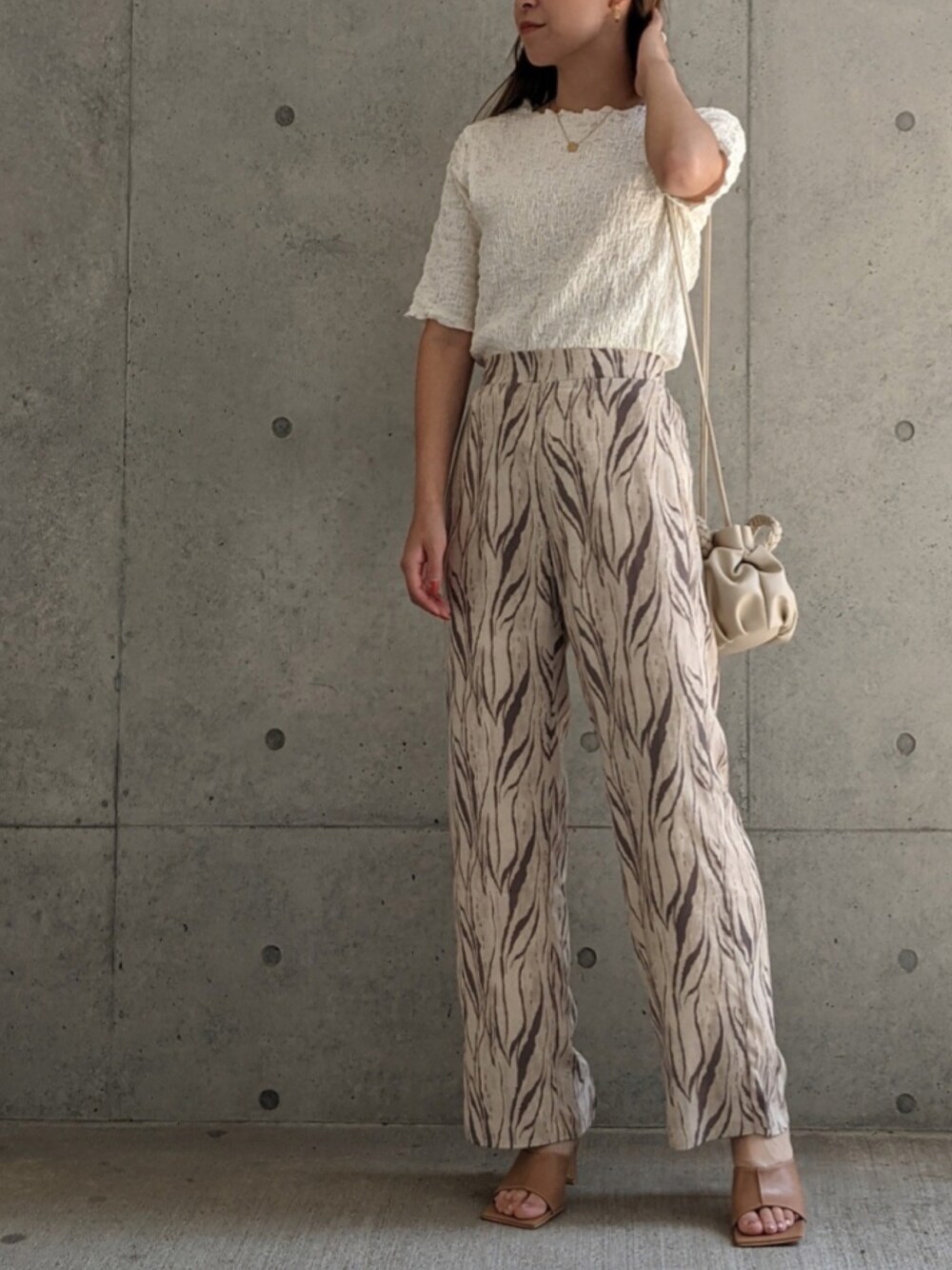 ホワイト系のその他パンツ、ホワイト系のショルダーバッグ、ベージュ系のTシャツ/カットソーを着用したレディースの夏コーディネートの1枚目の写真