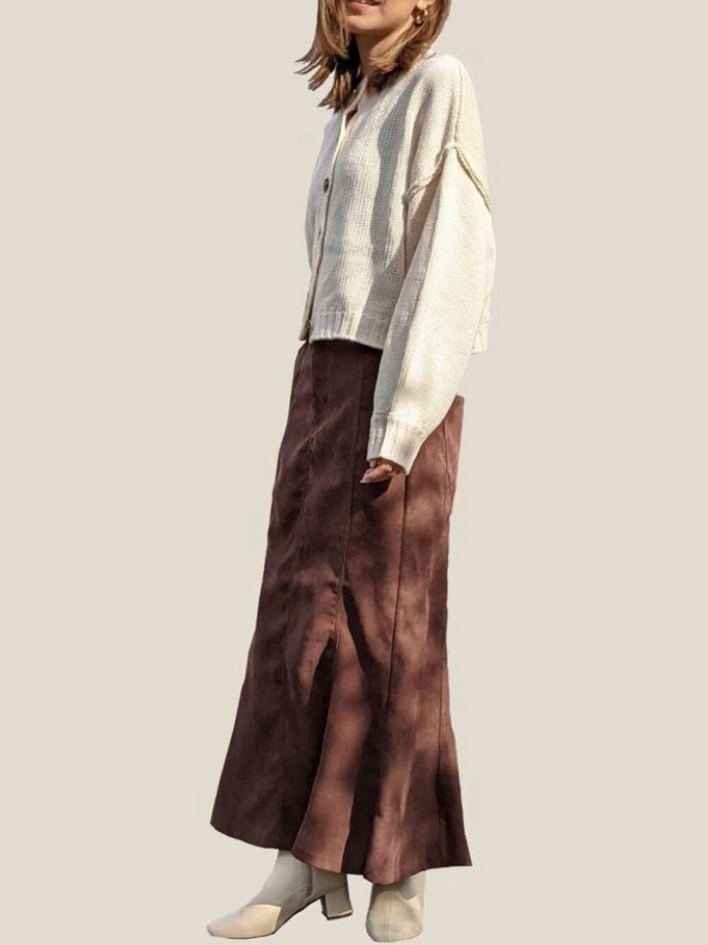 ホワイト系のカーディガン/ボレロ、ブラウン系のスカートを着用したレディースの冬コーディネートの1枚目の写真