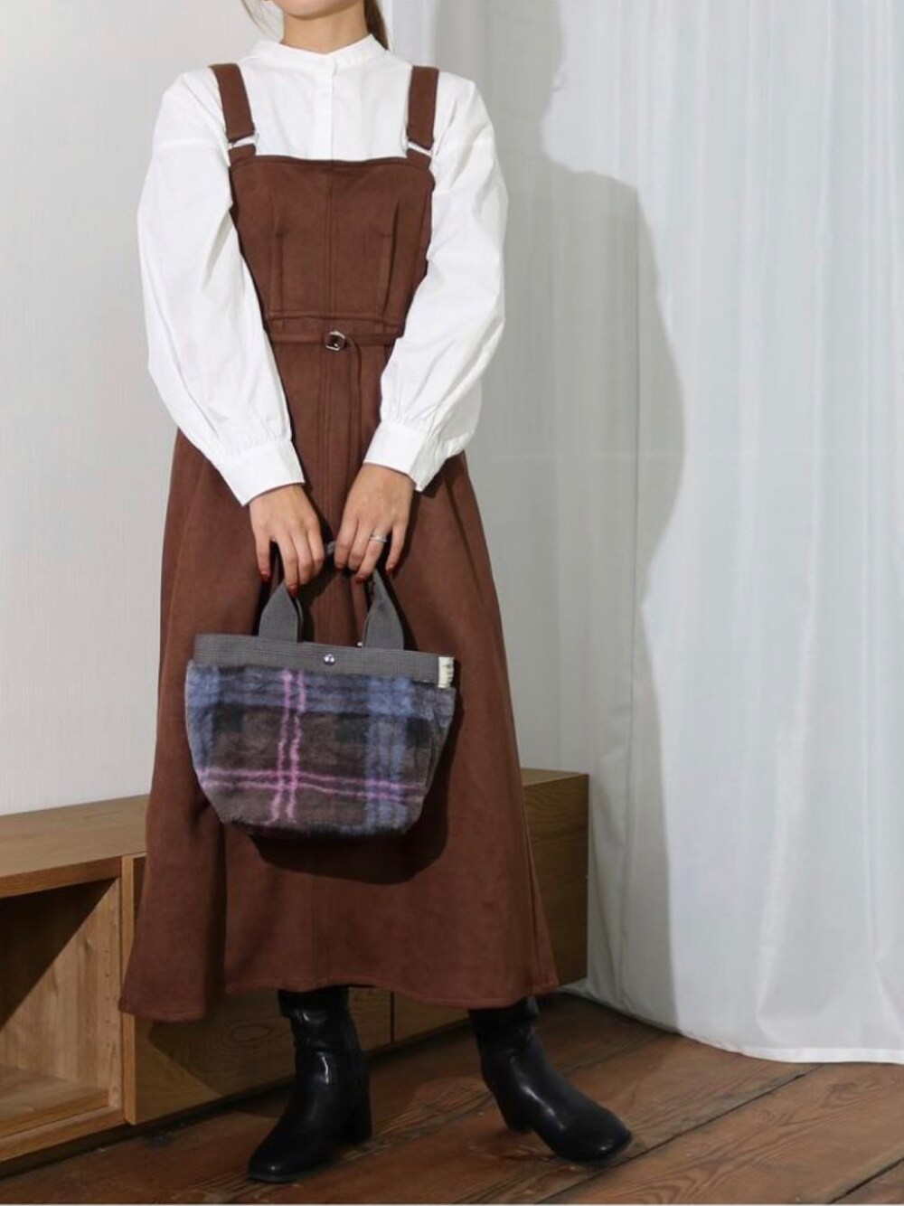 ブラウン系のジャンパースカートを着用したレディースの秋コーディネートの1枚目の写真