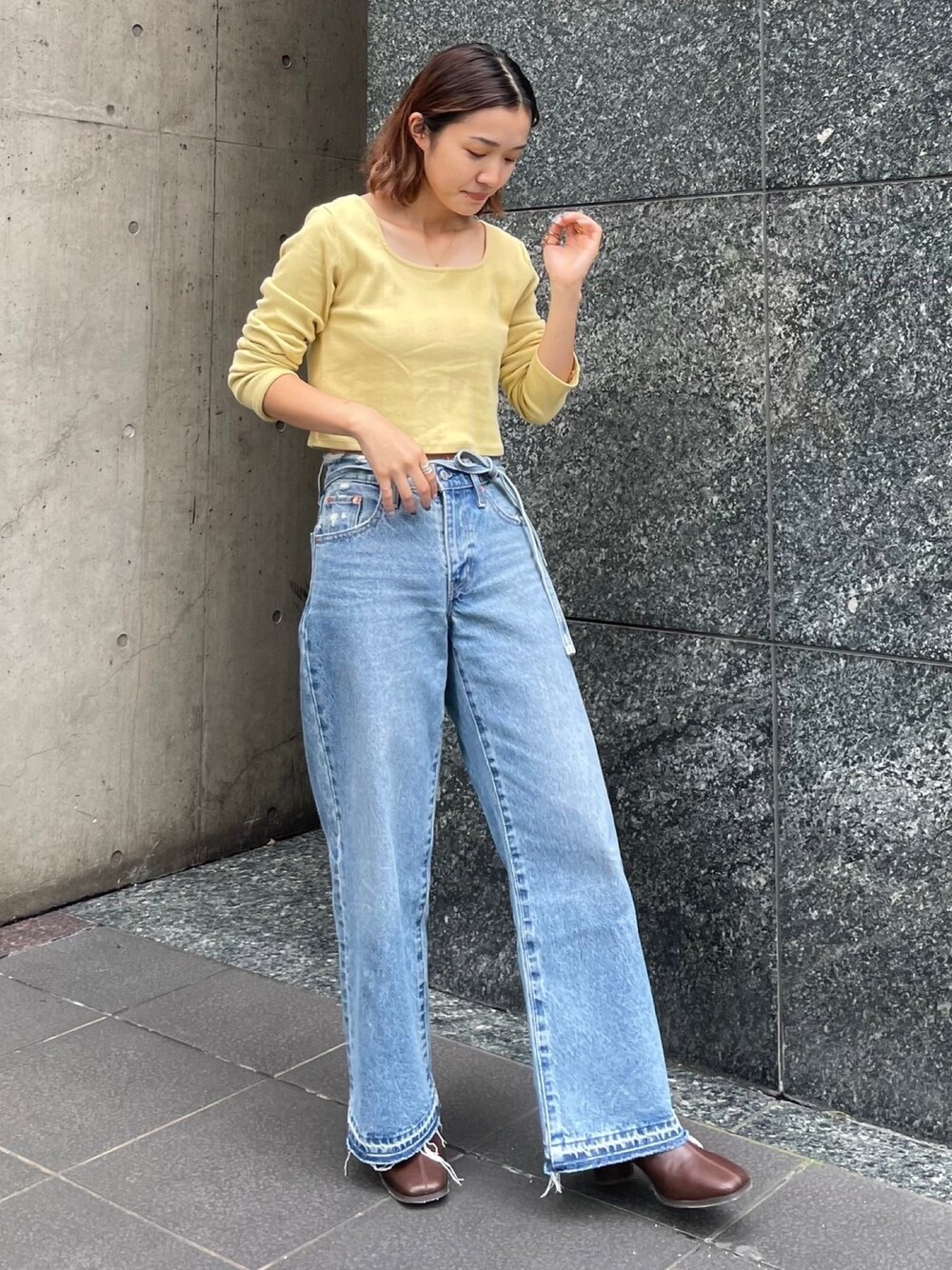 グリーン系のTシャツ/カットソー、ブルー系のデニムパンツ、ブラウン系のブーツを着用したレディースの秋コーディネートの1枚目の写真