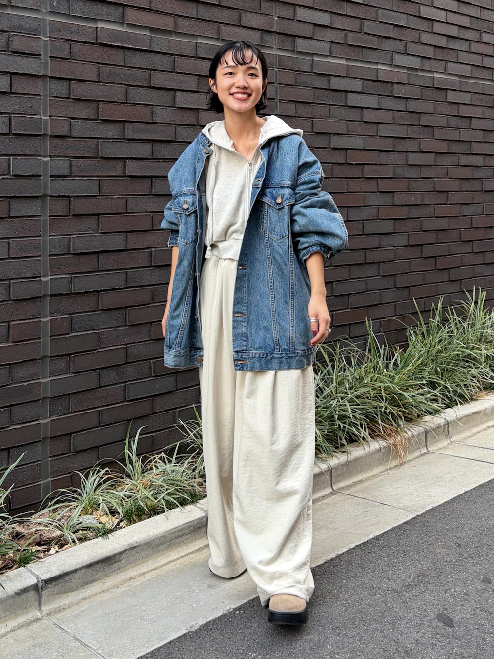 ブルー系のデニムジャケット、ホワイト系のその他パンツ、ホワイト系のパーカーを着用したレディースの秋コーディネートの1枚目の写真
