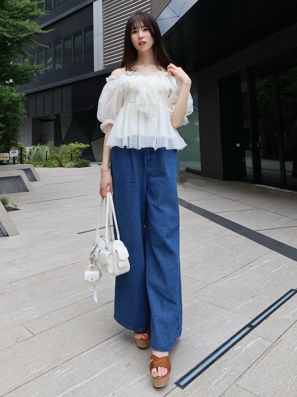ホワイト系のボストンバッグ、ホワイト系のシャツ/ブラウス、ブルー系のデニムパンツを着用したレディースの夏コーディネートの1枚目の写真