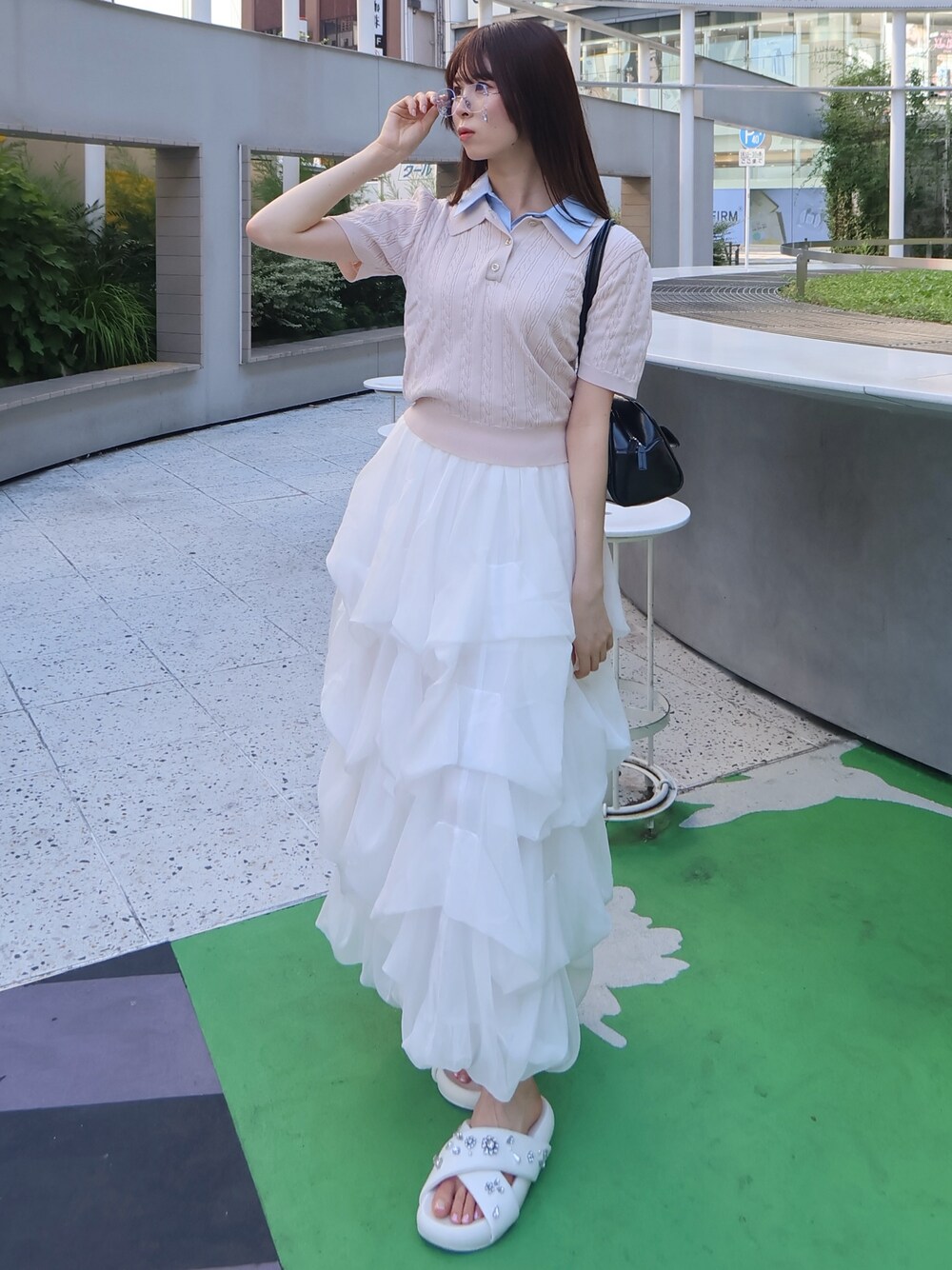 ピンク系のニット/セーター、ホワイト系のスカートを着用したレディースの夏コーディネートの1枚目の写真