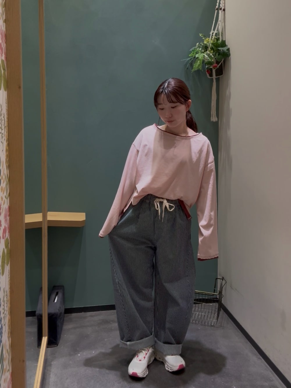 ホワイト系のスニーカー、ピンク系のTシャツ/カットソー、ブルー系のデニムパンツを着用したレディースの秋コーディネートの1枚目の写真