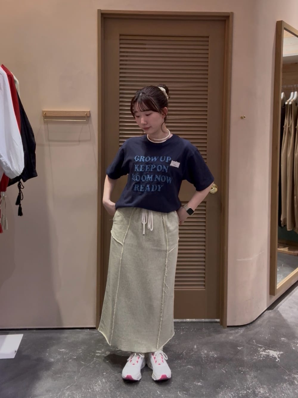 ブルー系のTシャツ/カットソー、イエロー系のスカート、ホワイト系のスニーカーを着用したレディースの秋コーディネートの1枚目の写真
