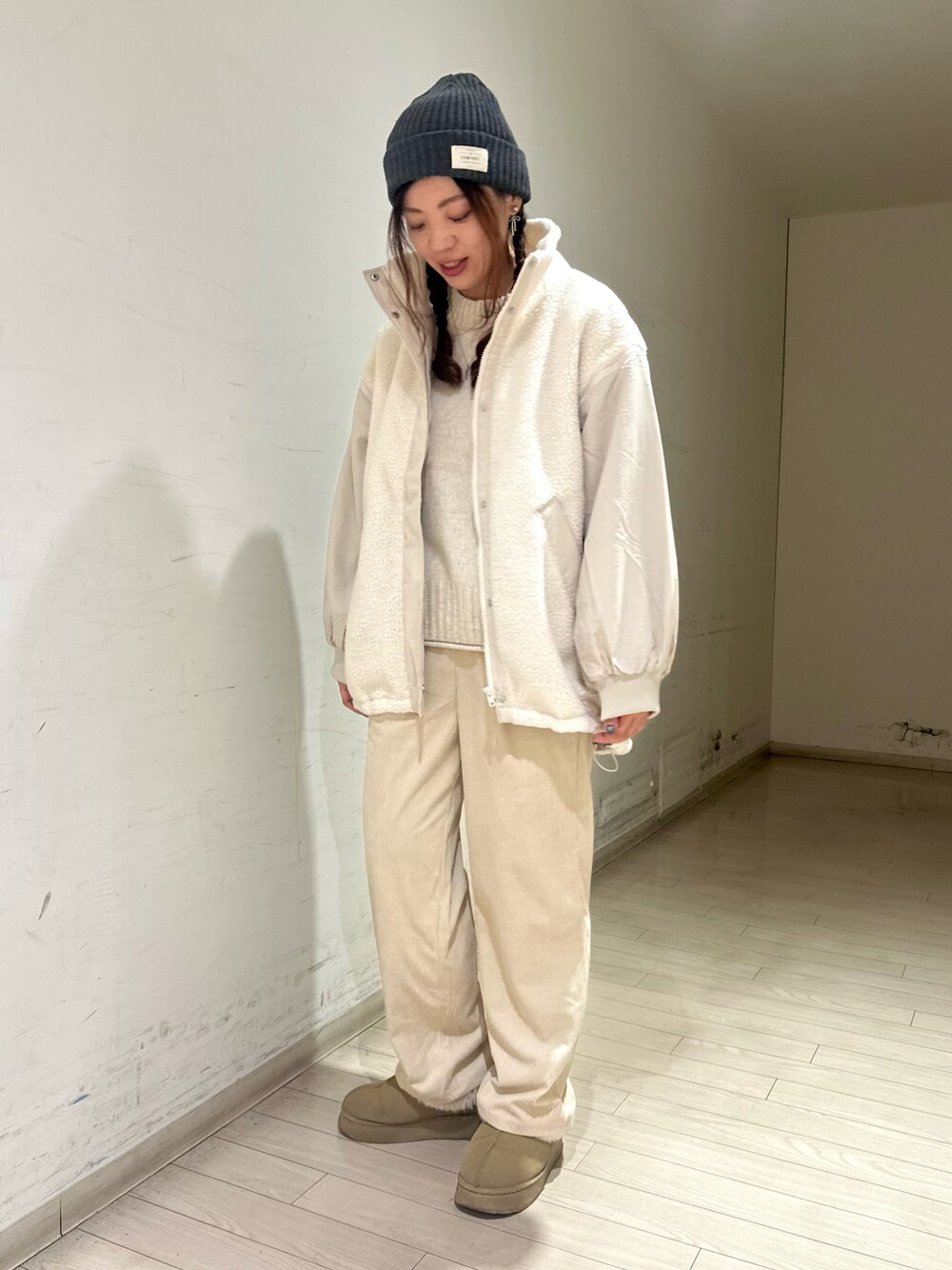 ホワイト系のブルゾン、ホワイト系のトップス、ホワイト系のパンツを着用したレディースの冬コーディネートの1枚目の写真