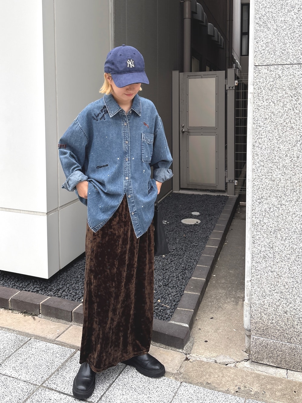 ブルー系のシャツ/ブラウス、ブラウン系のスカート、ブルー系のキャップを着用したレディースの秋コーディネートの1枚目の写真