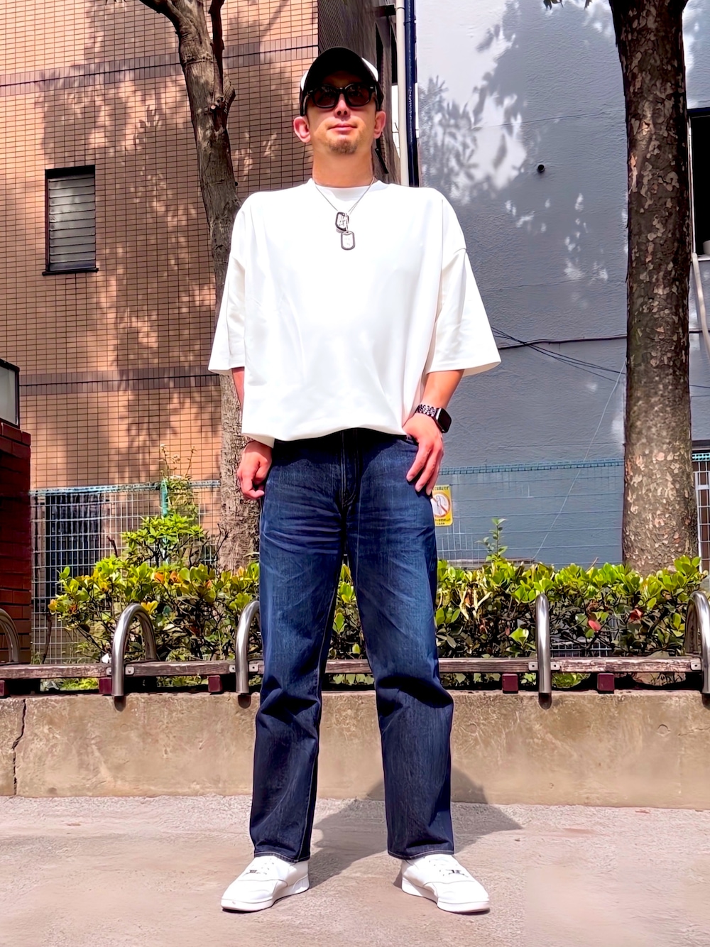 ホワイト系のTシャツ/カットソー、ブルー系のデニムパンツ、ホワイト系のスニーカーを着用したメンズの春コーディネートの1枚目の写真